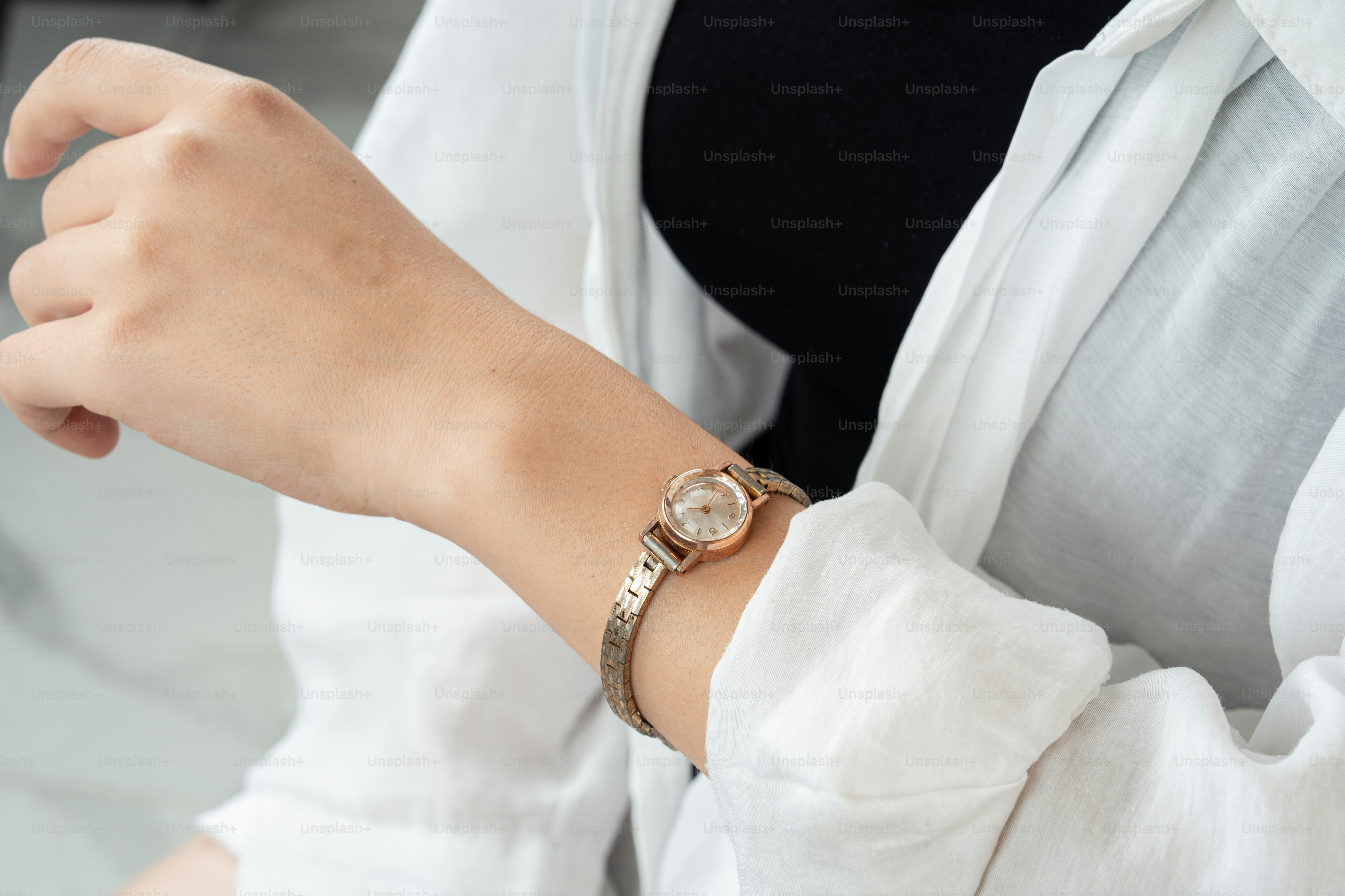 A woman wearing a watch and a white shirt