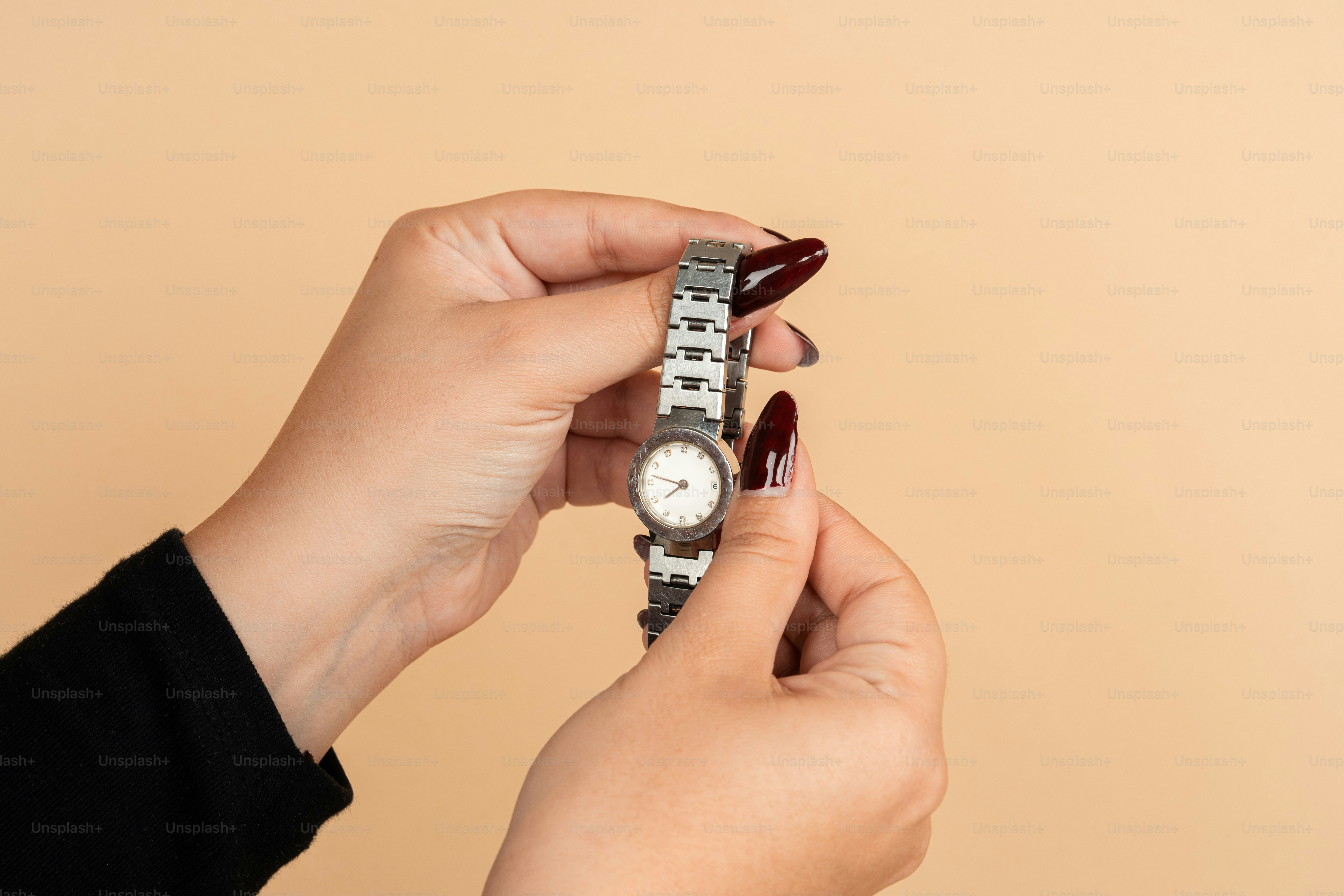 A woman holding a watch in her hand