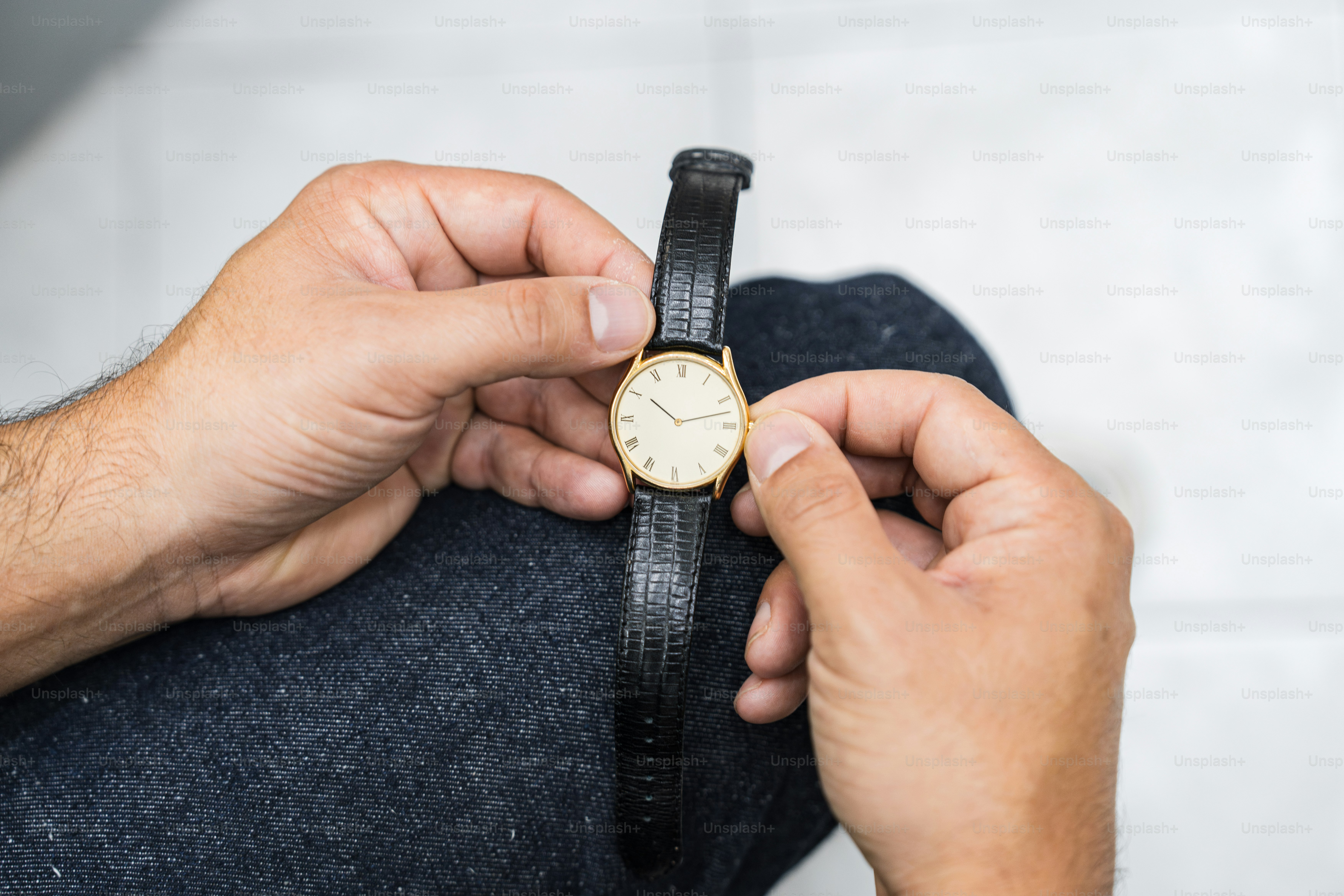 A man is holding a watch in his hand