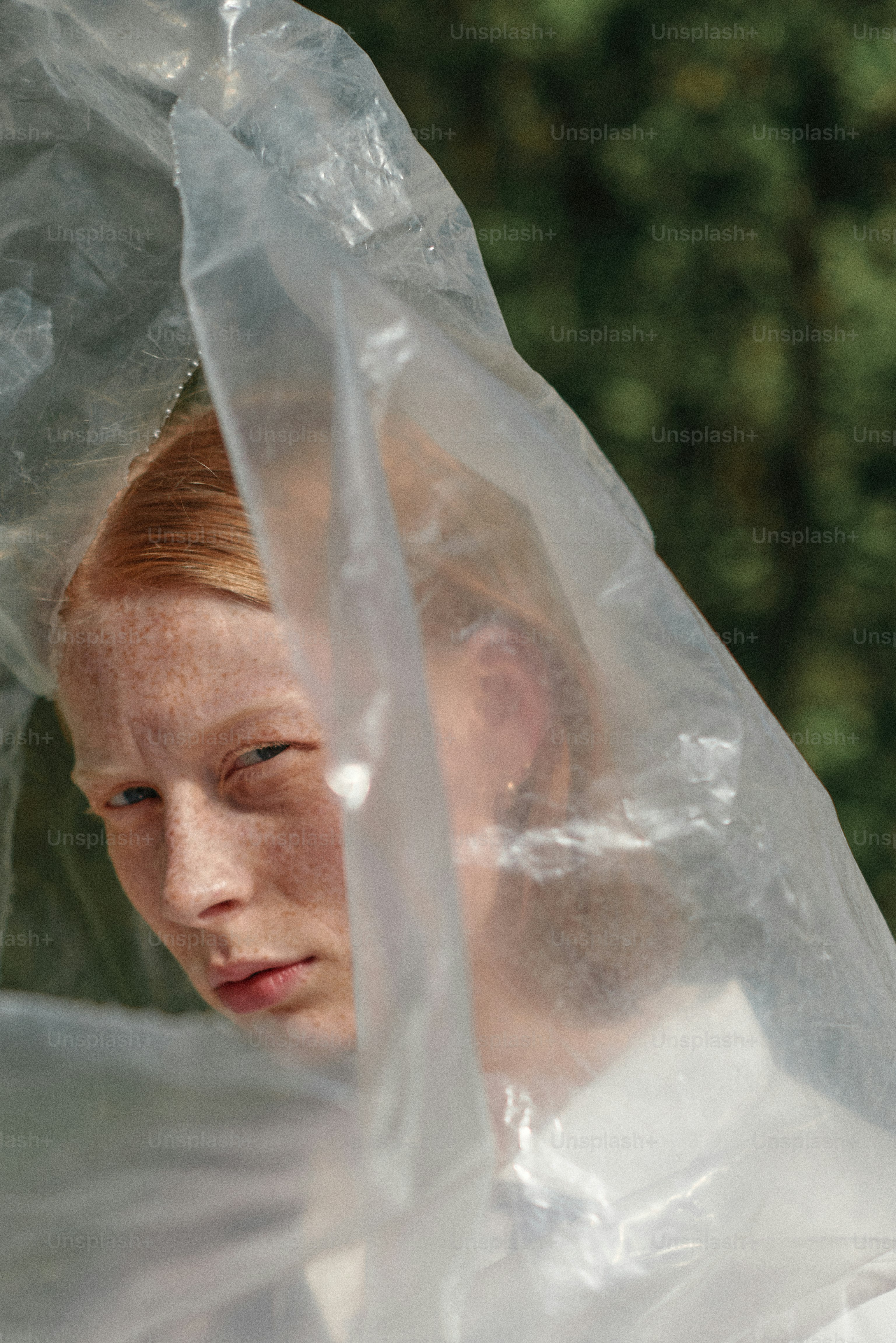 A woman in a white dress and a clear plastic covering her head
