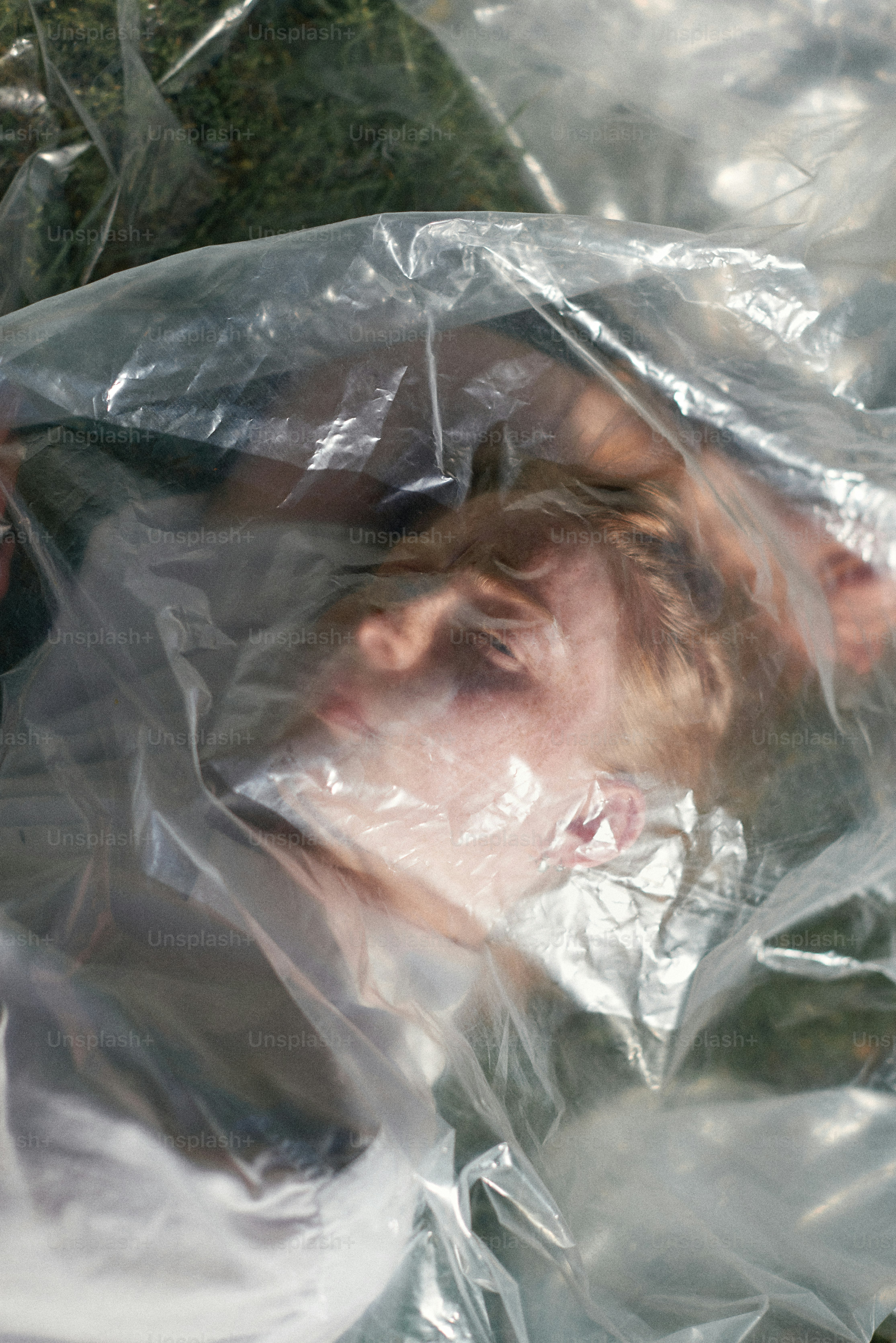 A man laying in a plastic bag on the ground