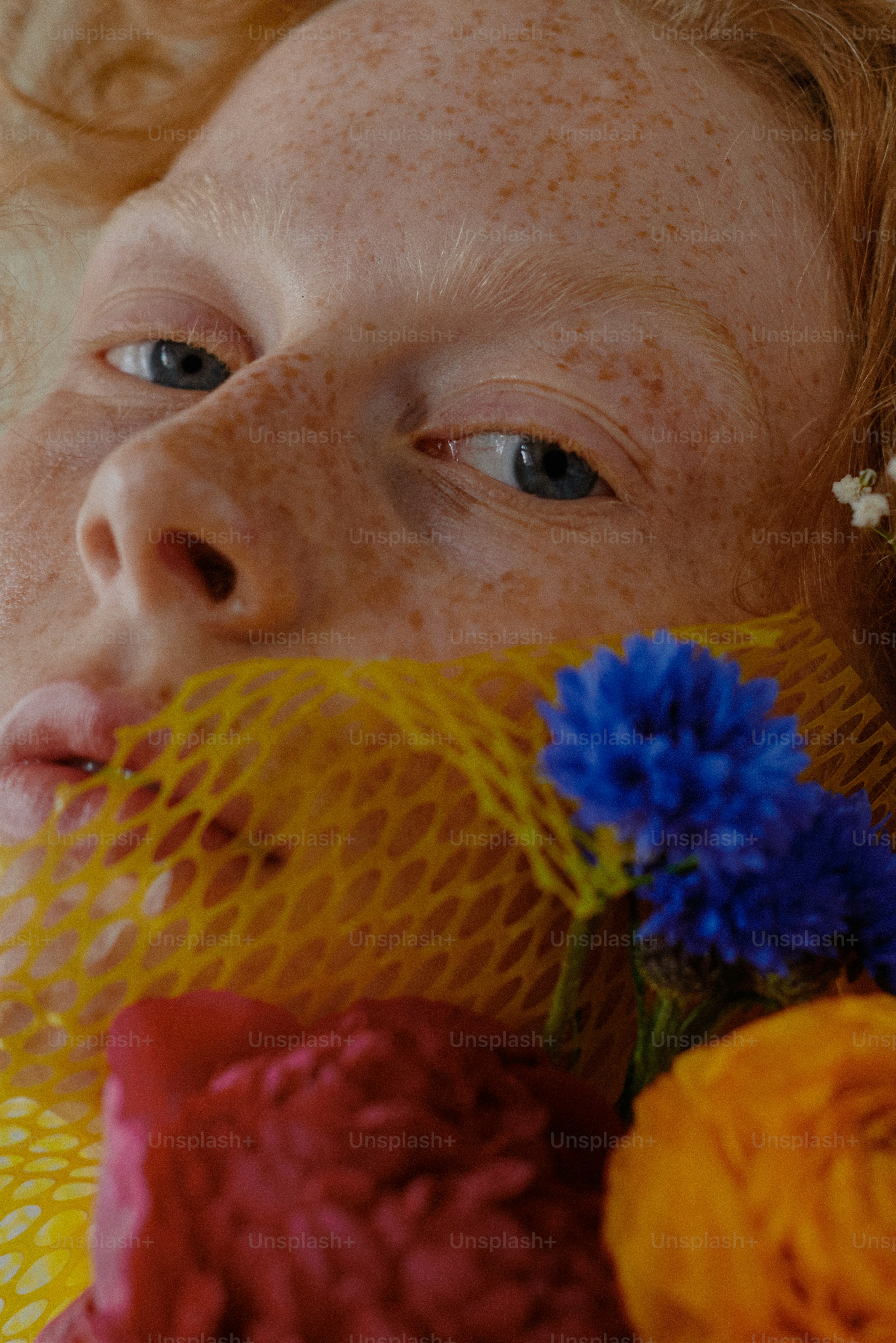 Una donna con i capelli lentigginosi e fiori sul viso