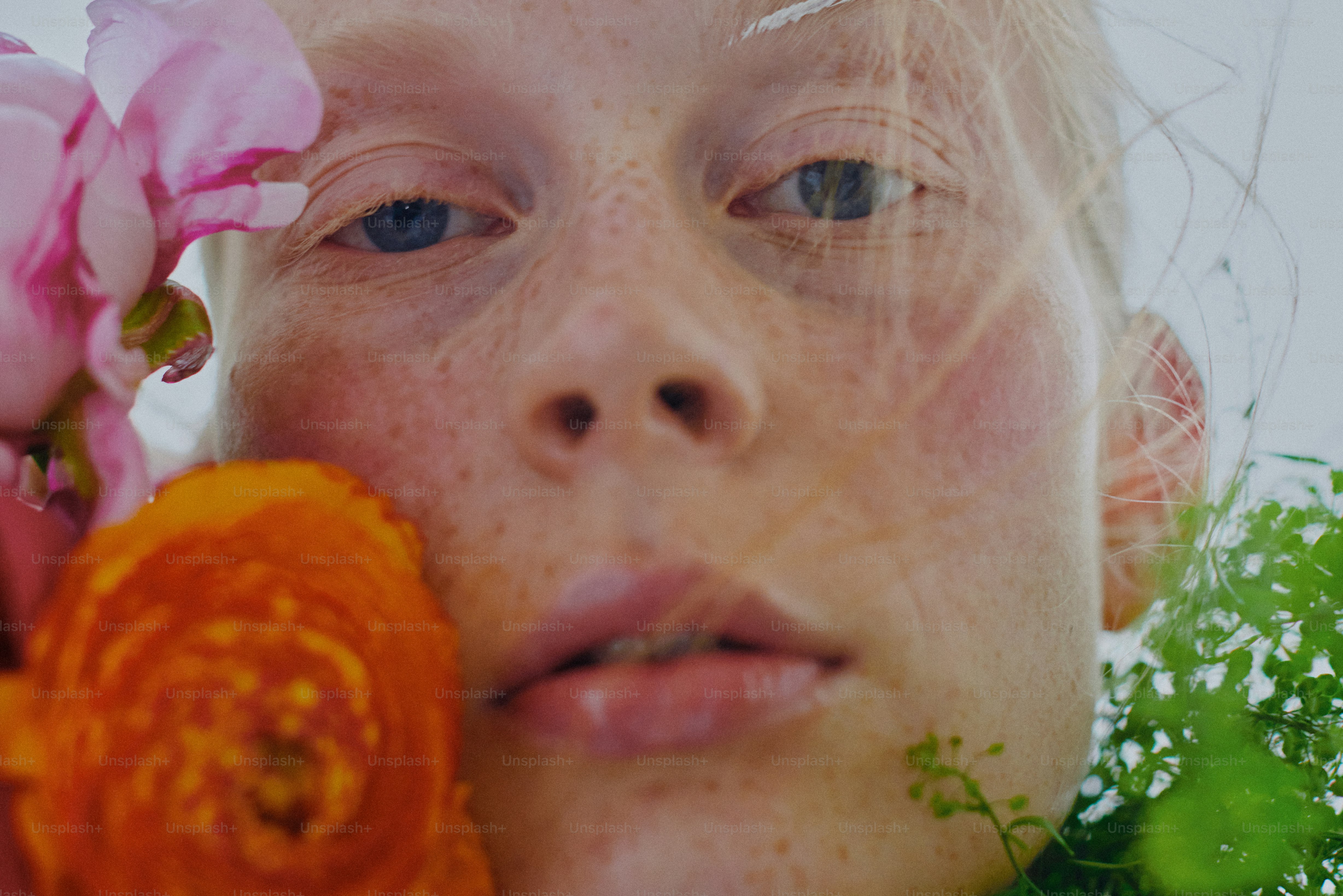 Una mujer sosteniendo una flor frente a su cara