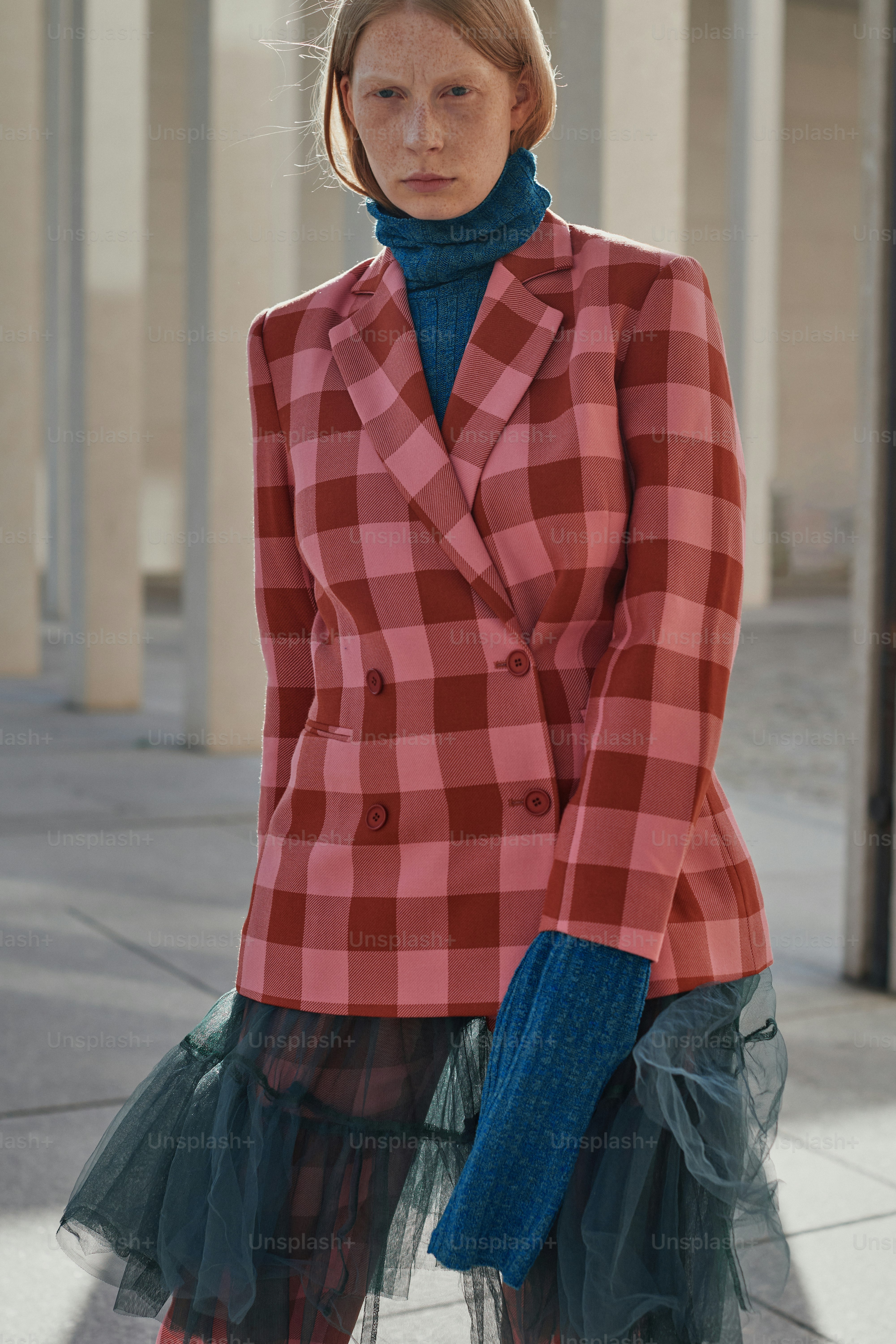 Uma mulher em uma jaqueta vermelha e preta e saia