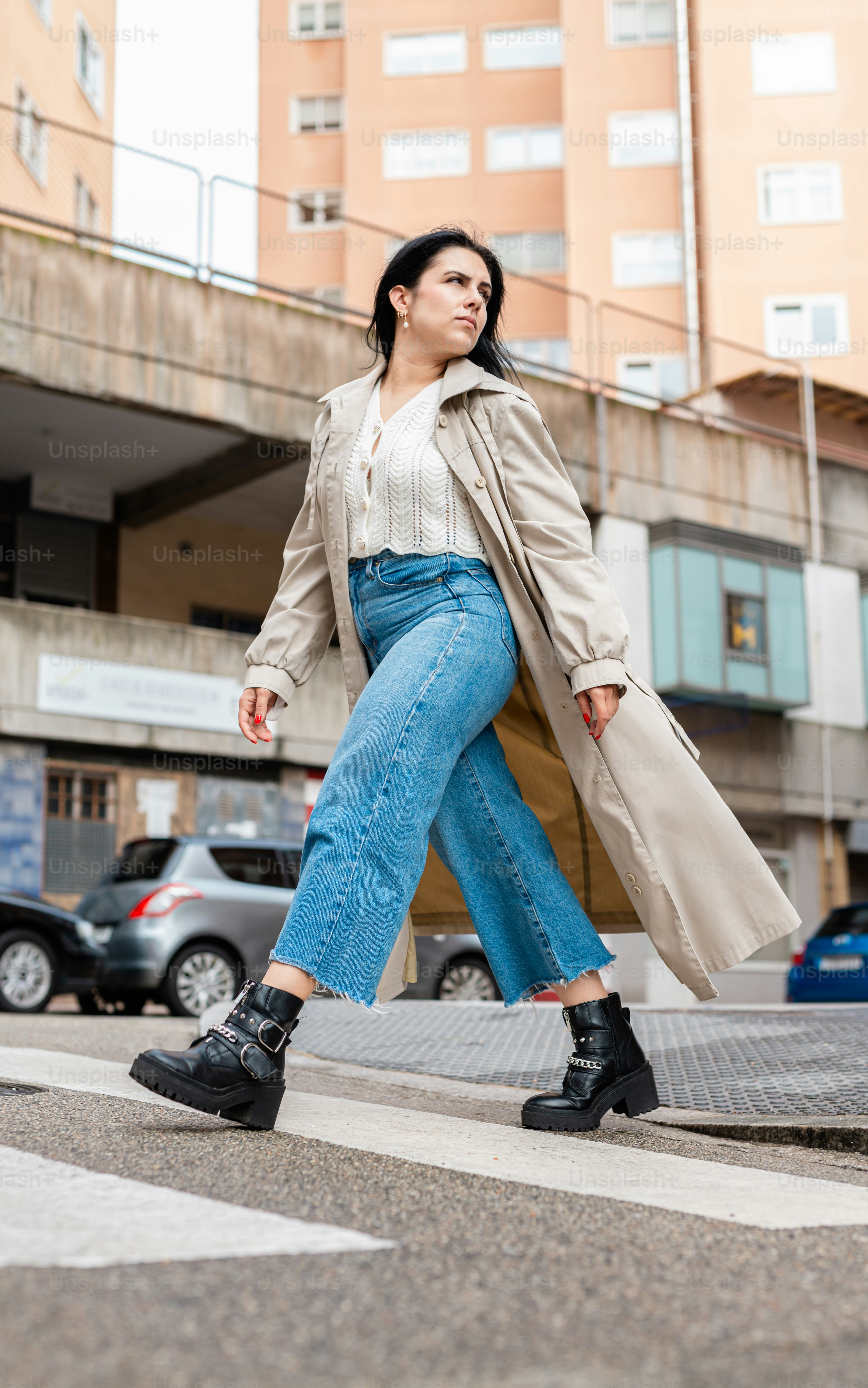 A woman crossing the street in a city