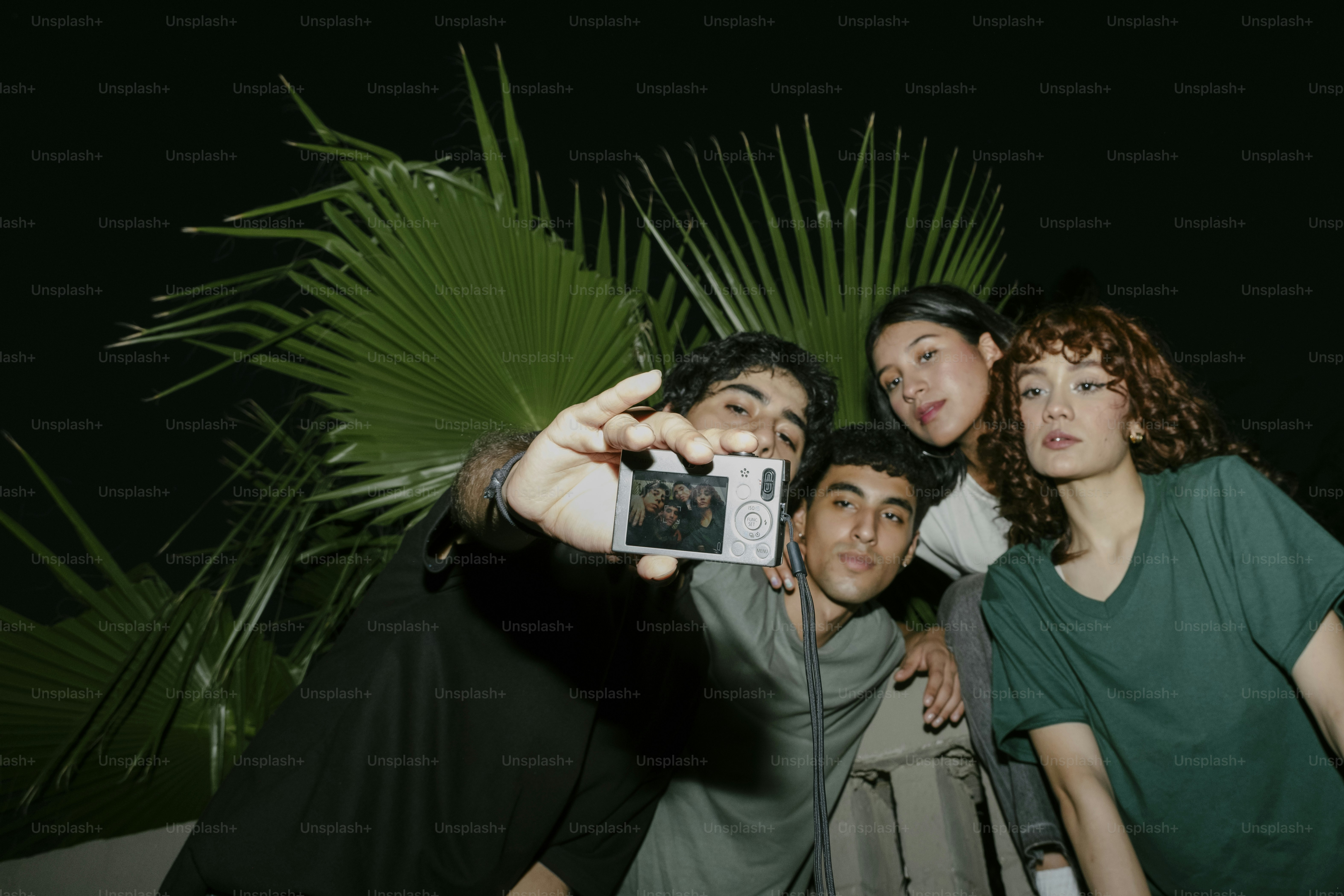 A group of people taking a picture with a cell phone