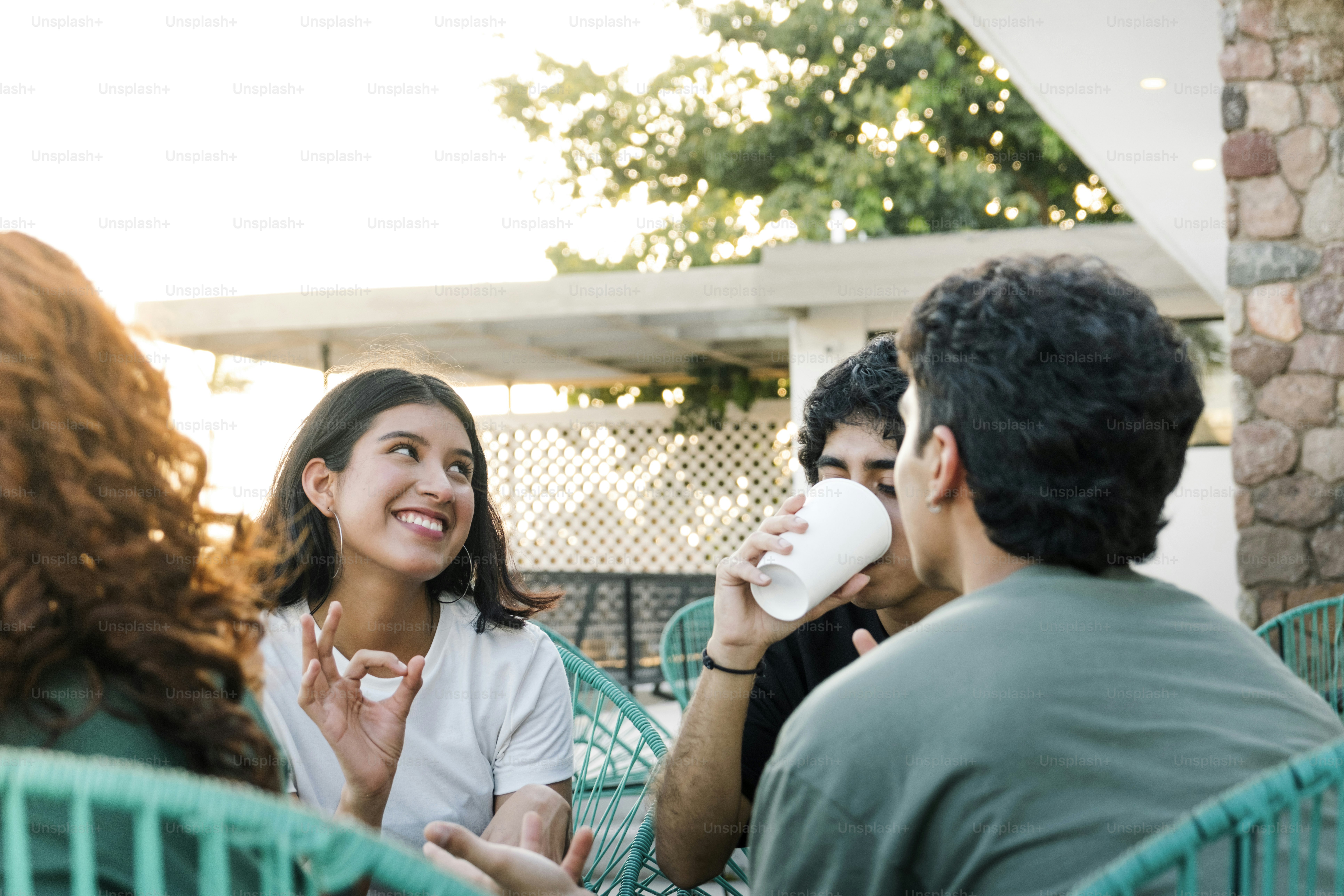 A group of people sitting around a table drinking coffee