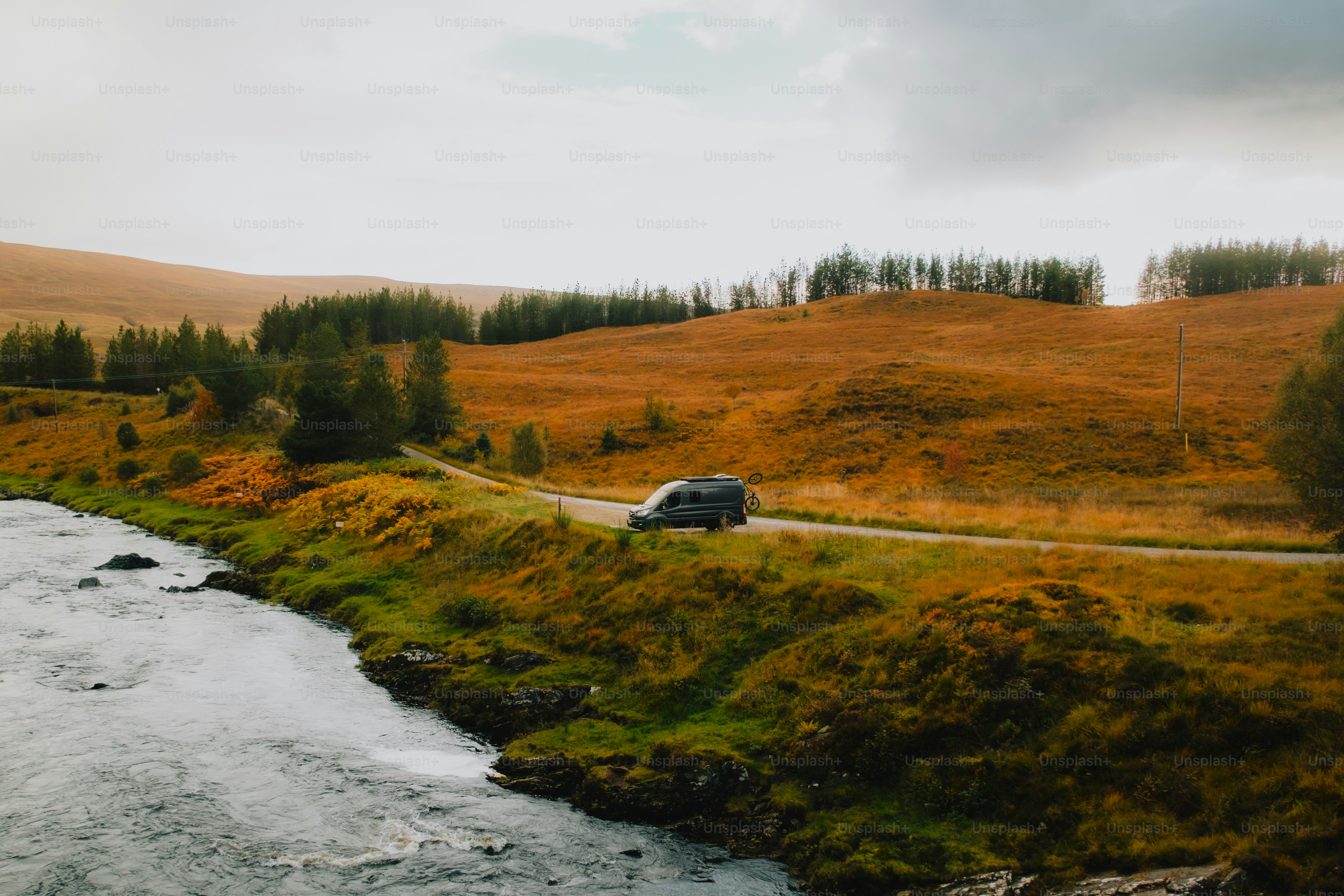 A car driving down a road next to a river