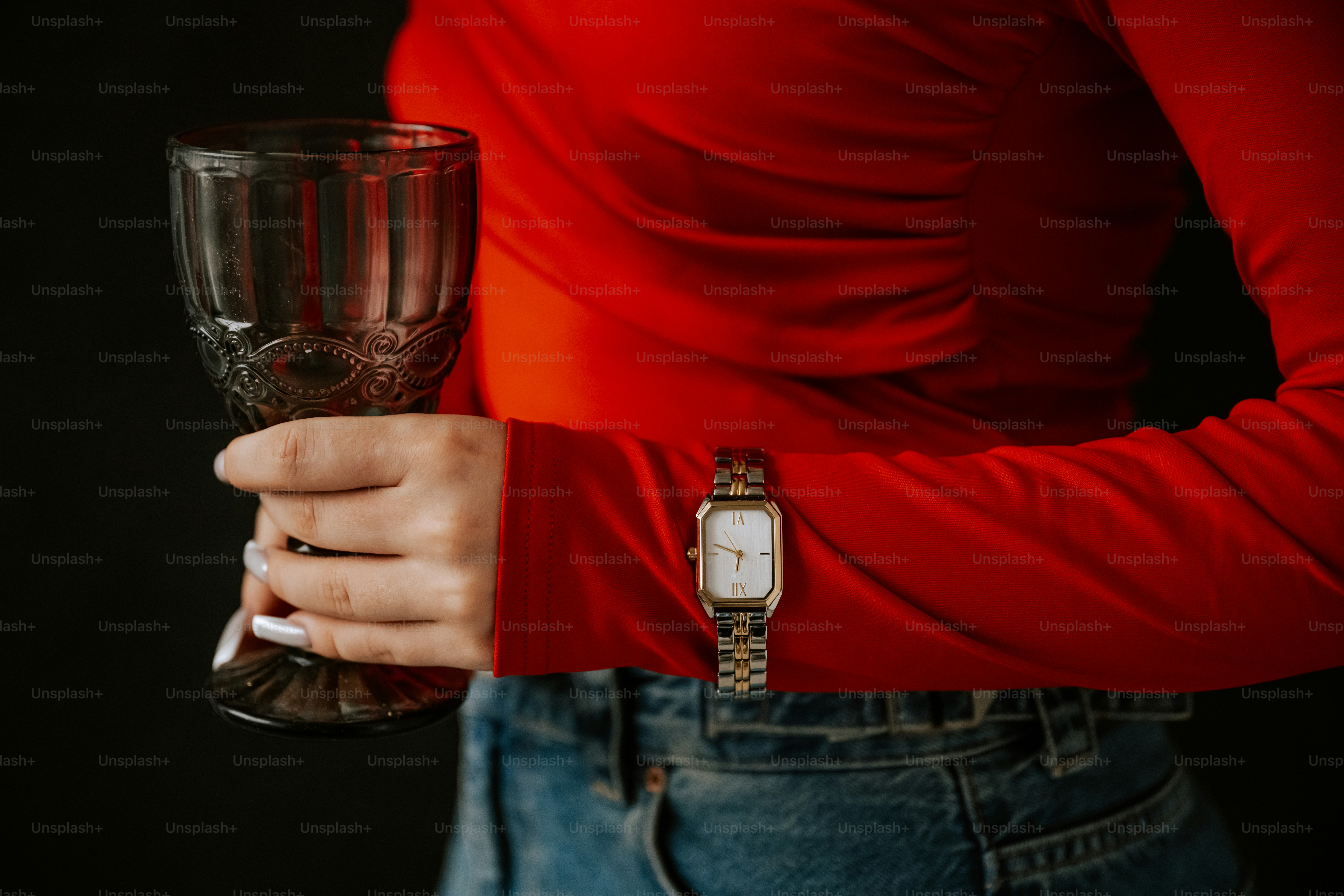 A man in a red shirt holding a wine glass