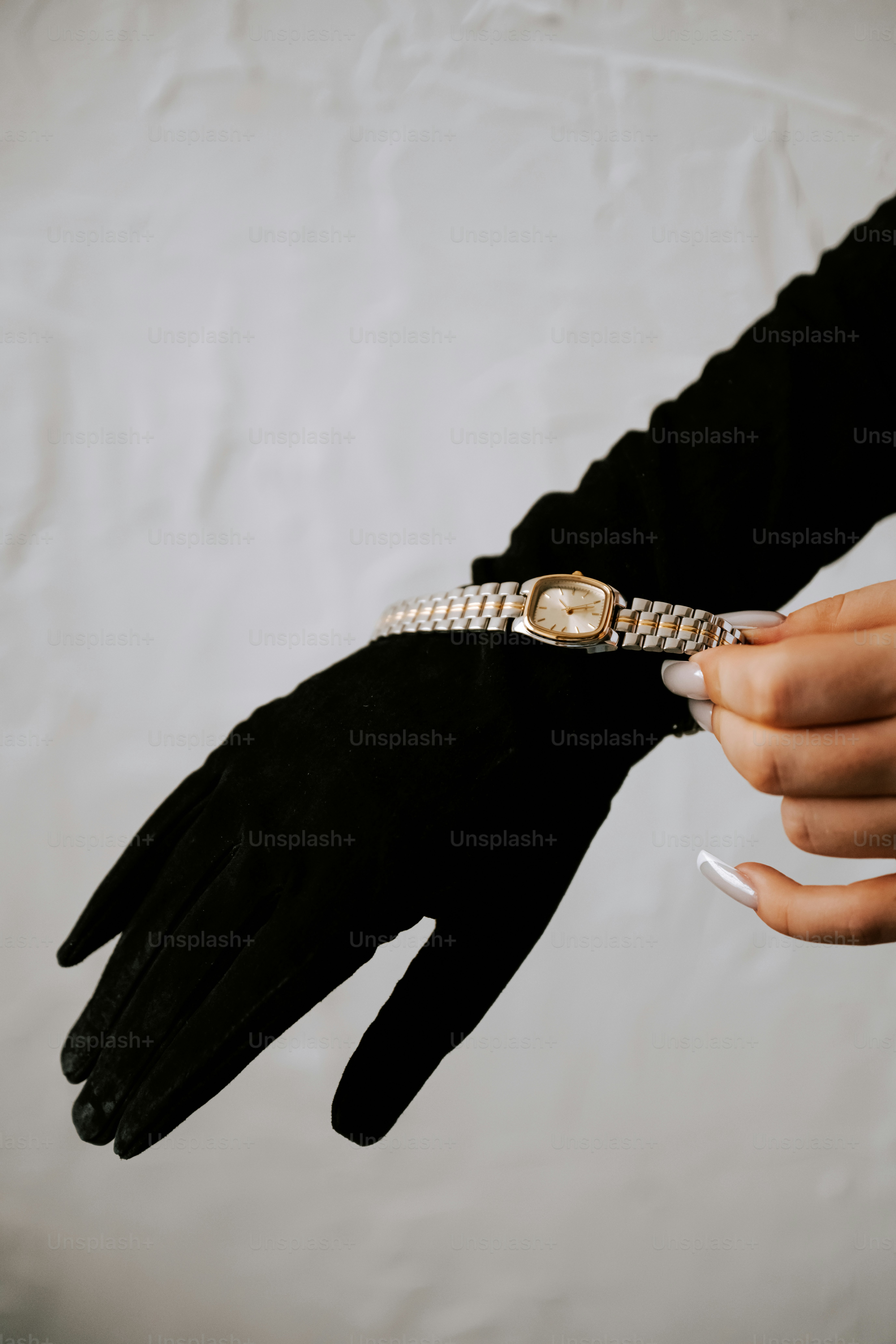 A person wearing a black glove holding a cigarette