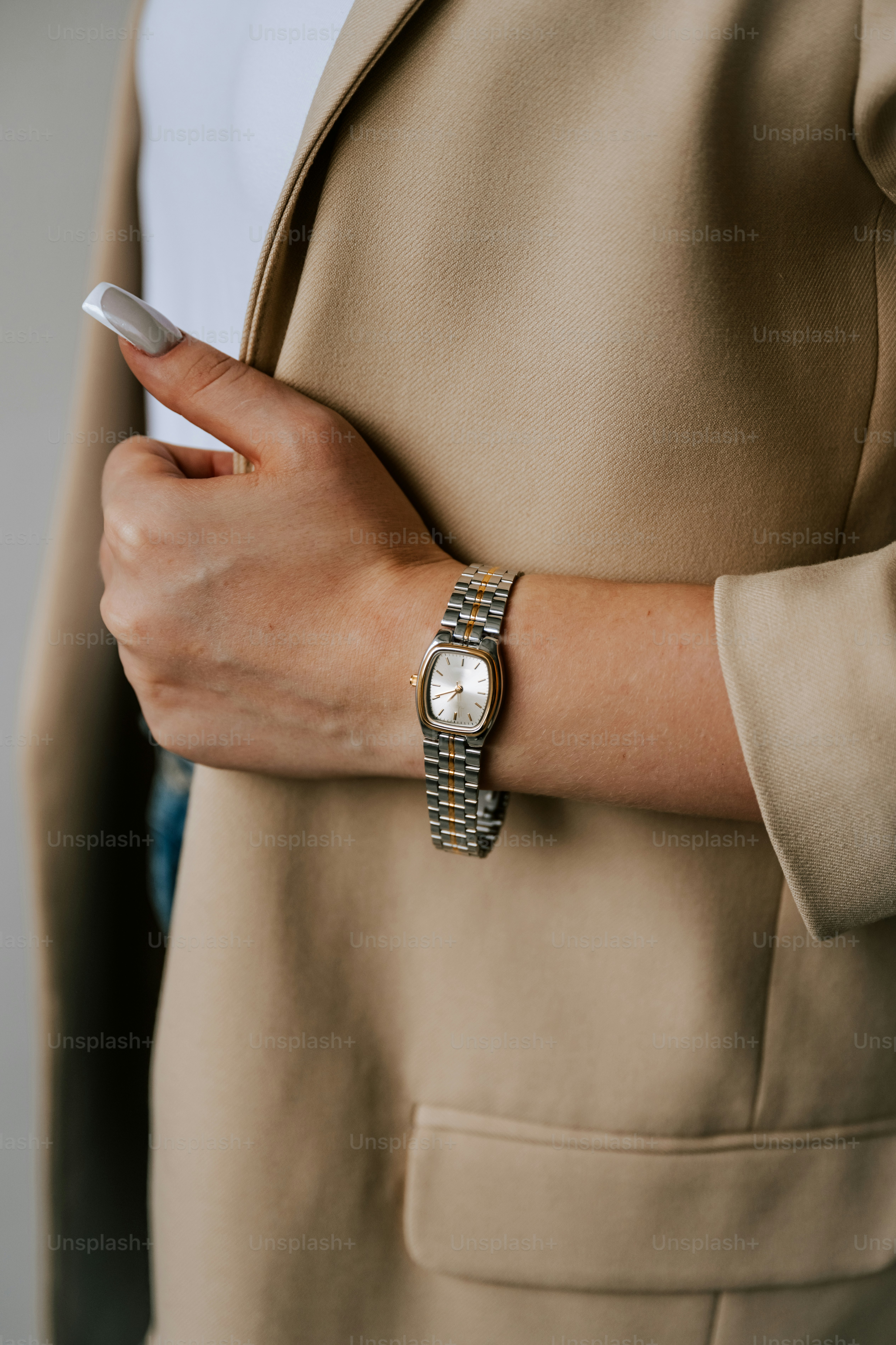 A woman in a beige jacket holding a cell phone