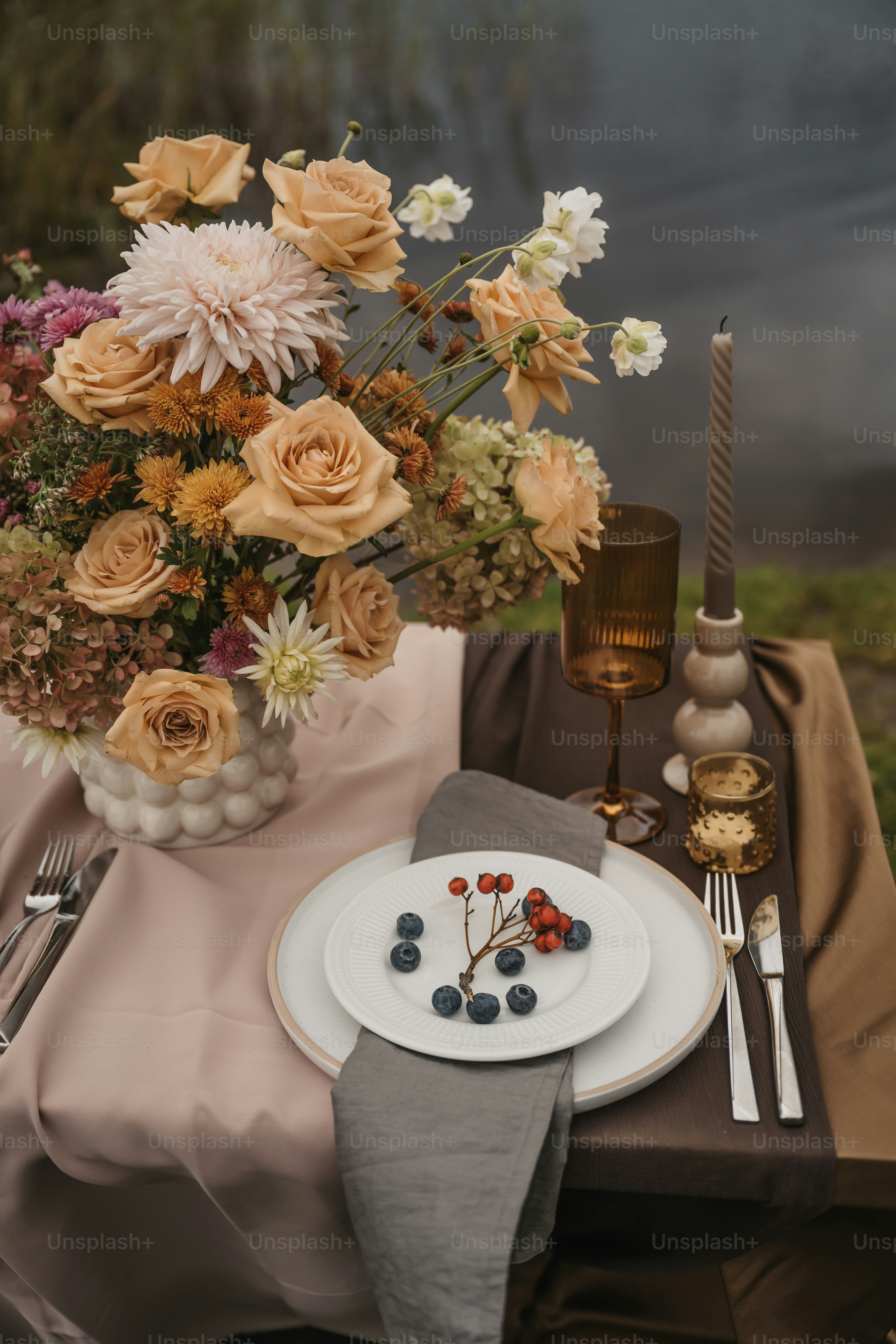 Une table dressée avec un vase de fleurs et une assiette