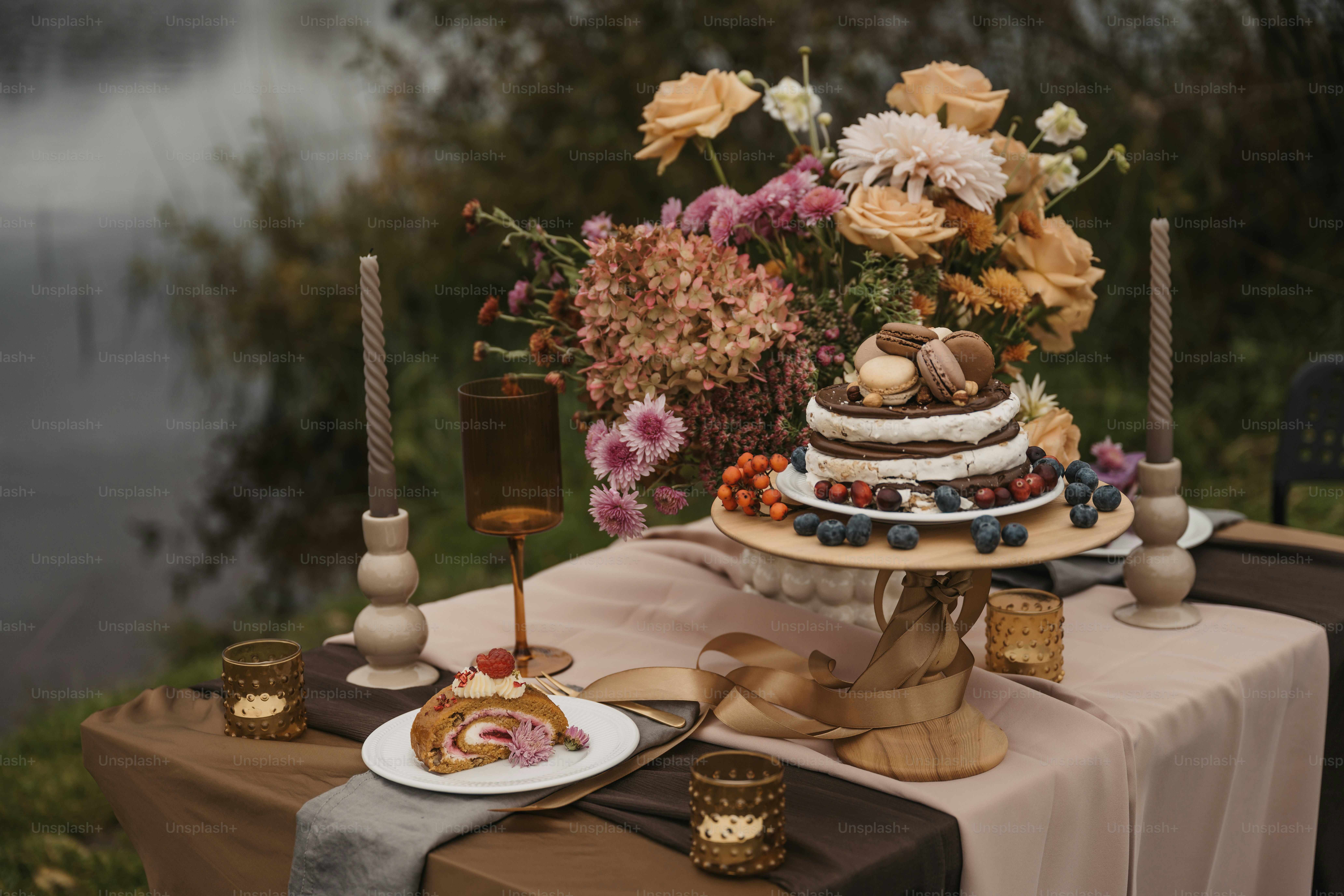 A table topped with a cake next to a lake