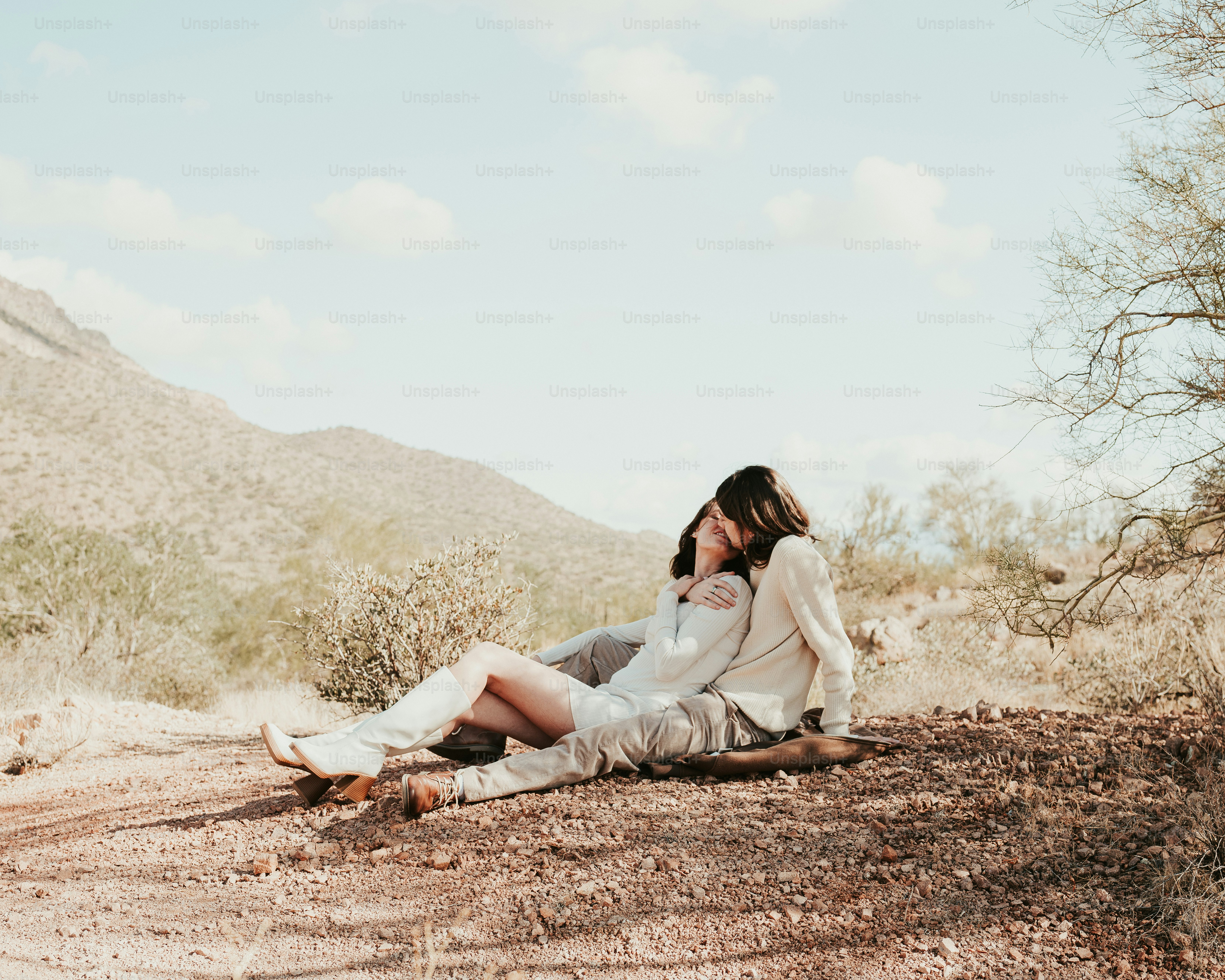 A woman sitting on the ground in the desert