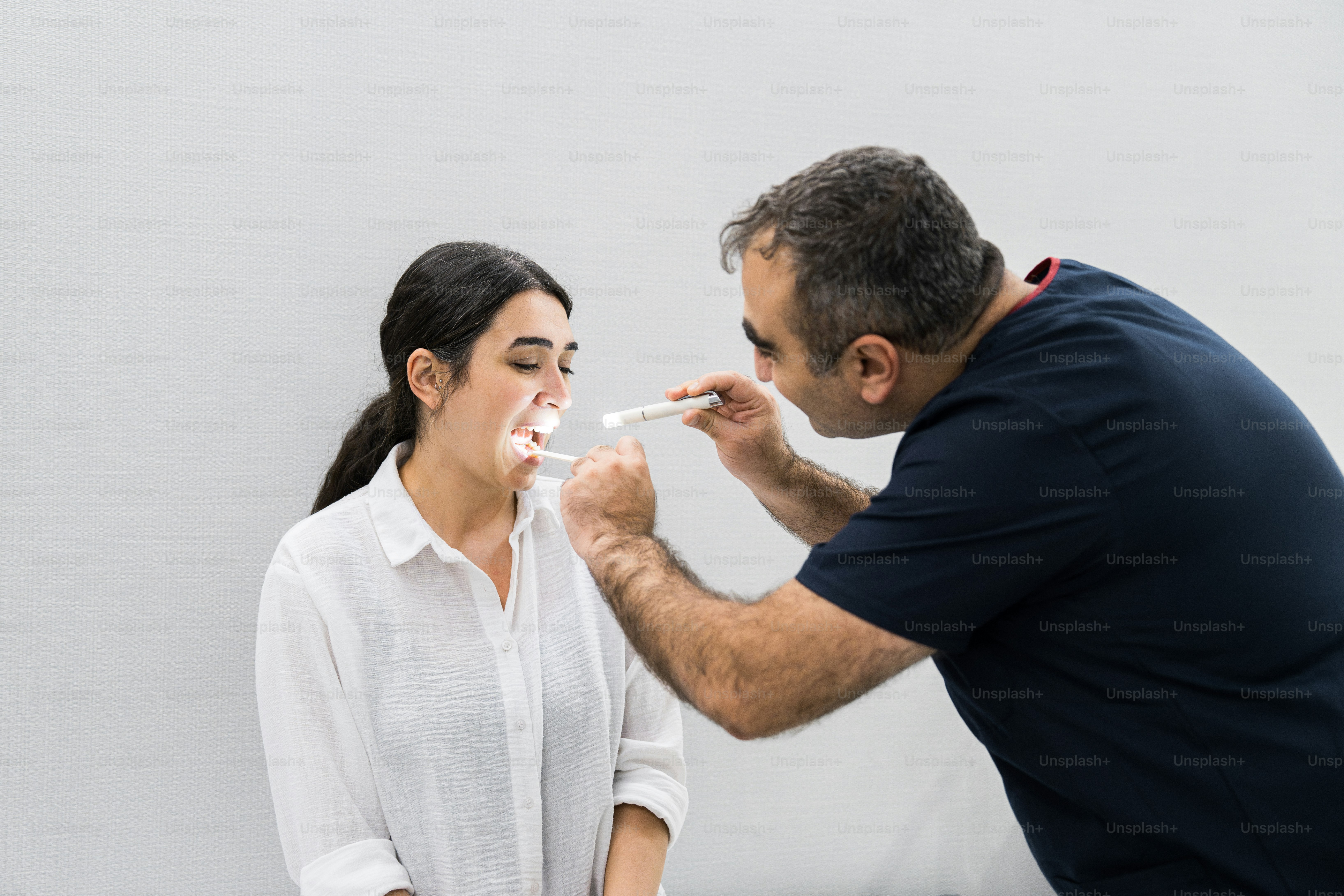 Un homme brosse les dents d’une femme avec une brosse à dents