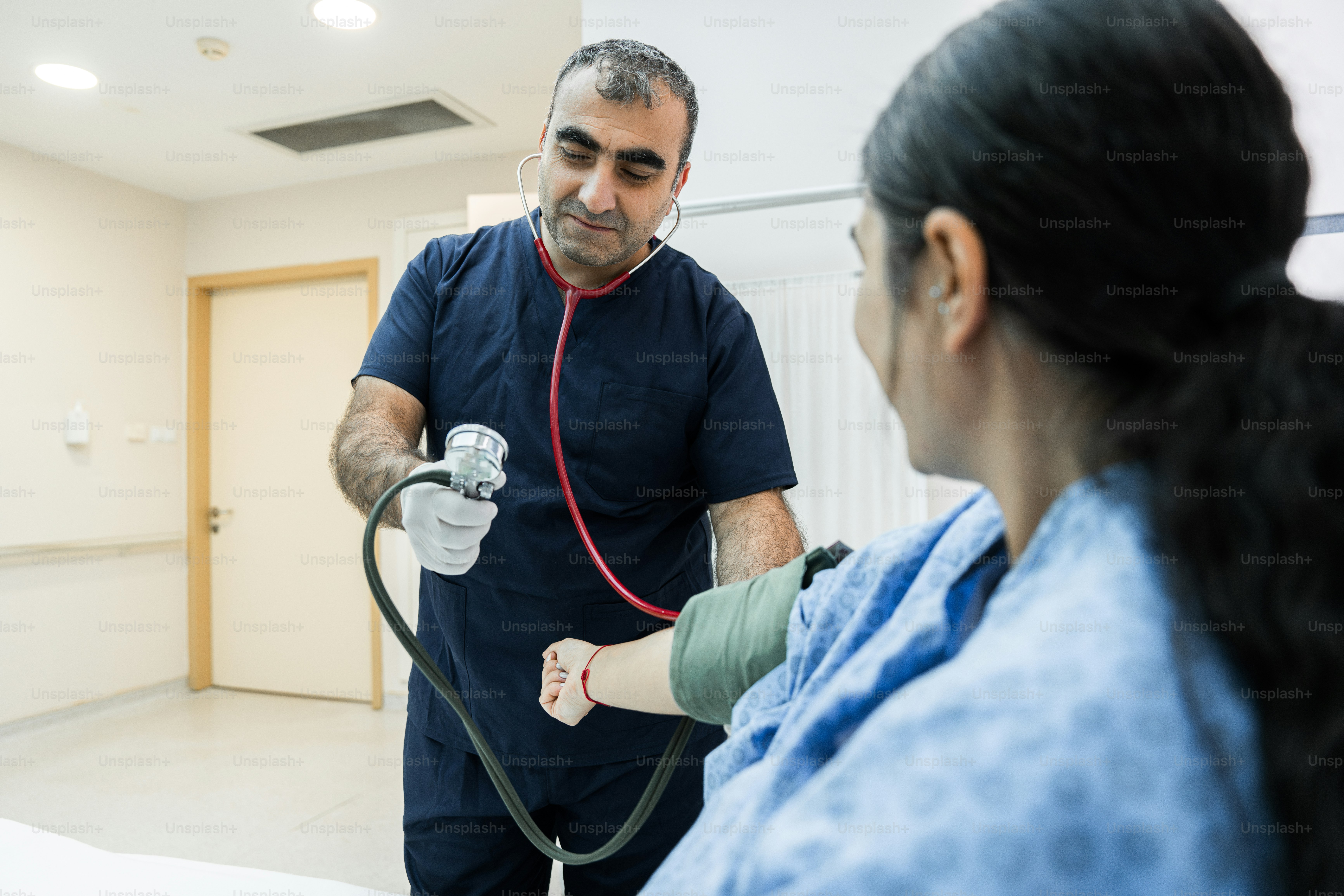Un homme avec un stéthoscope dans une chambre d’hôpital