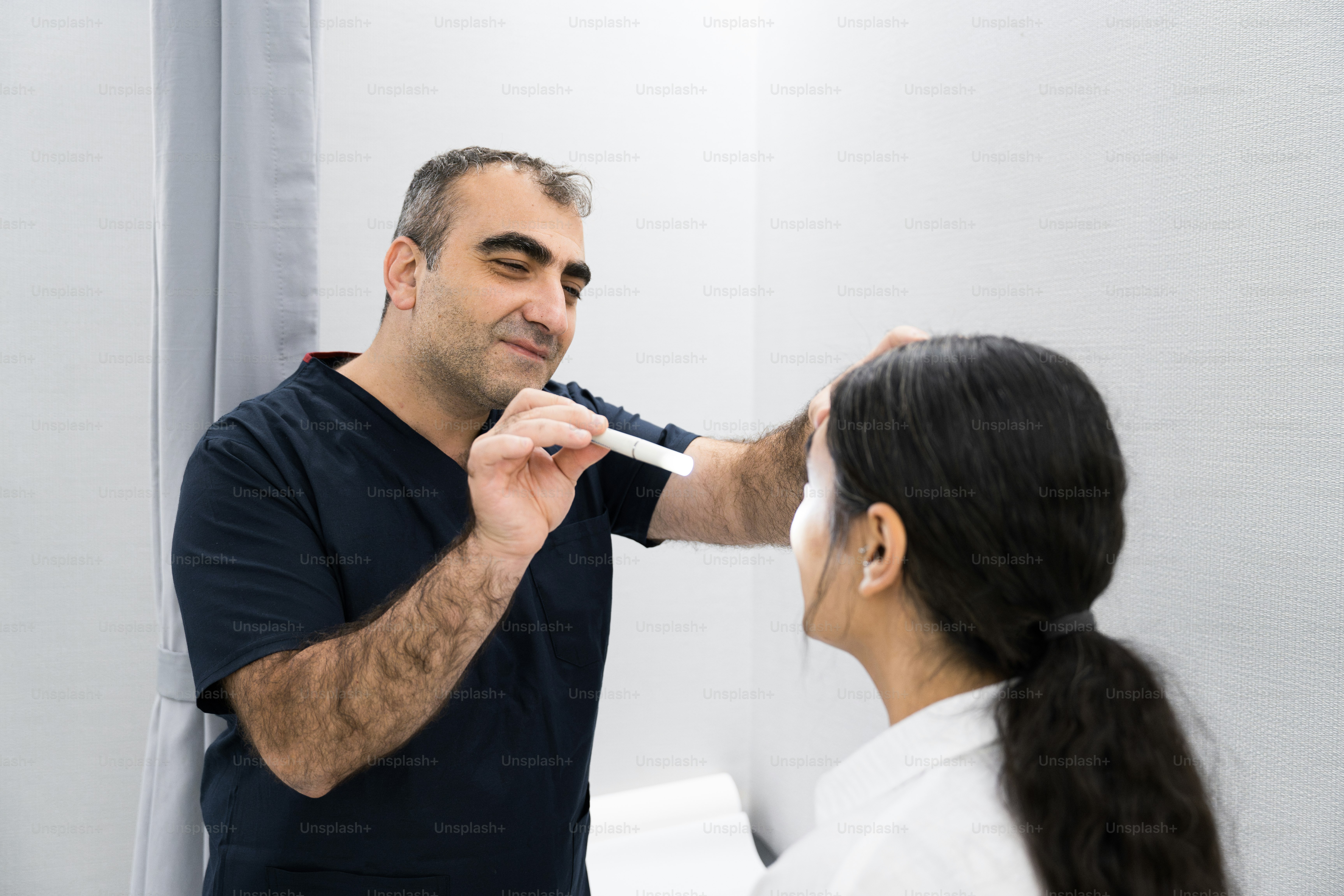 Un homme rase le visage d’une femme devant un miroir