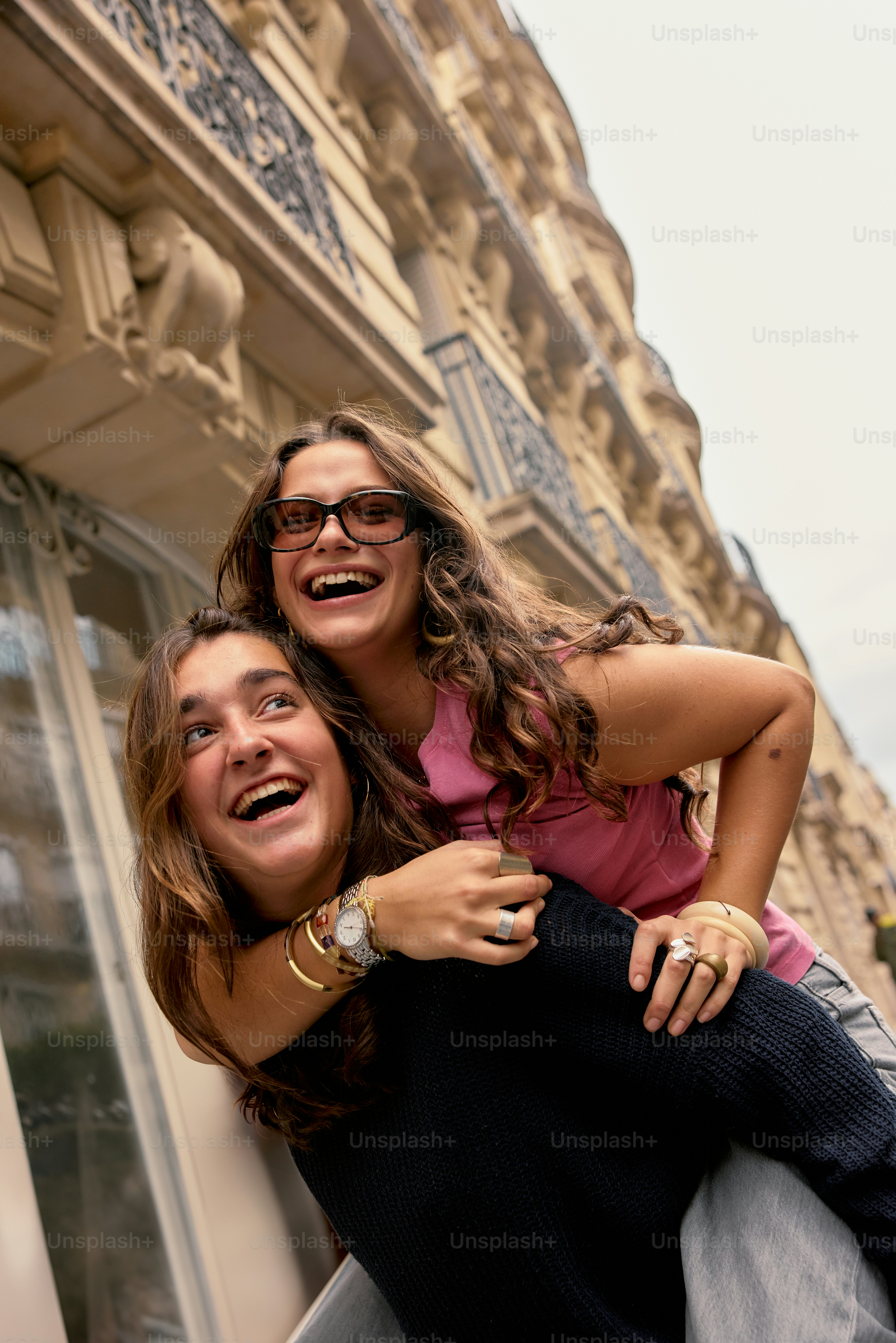 A couple of women standing next to each other in front of a building