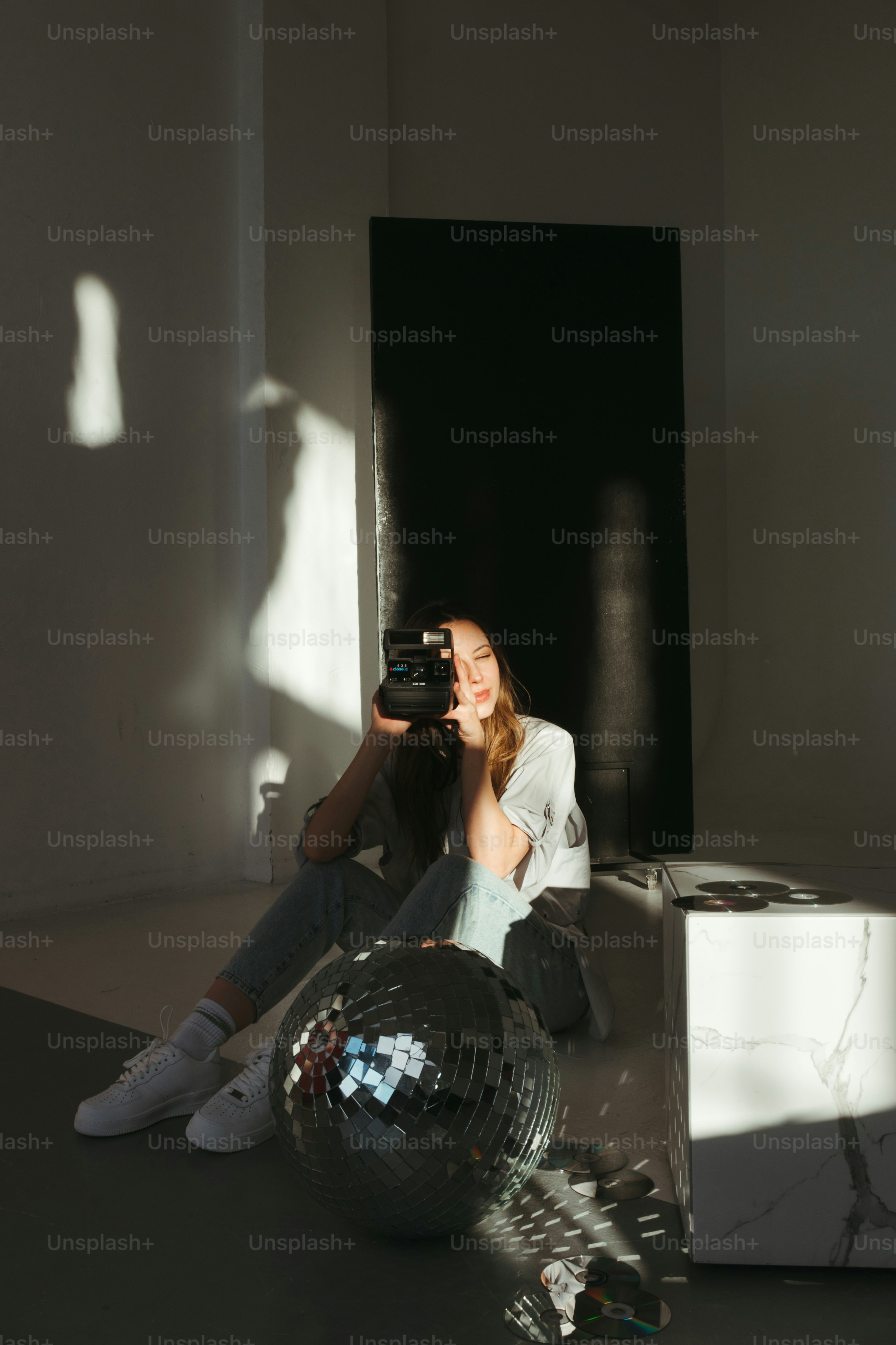 Eine Frau, die mit einer Spiegelkugel in einem Raum sitzt