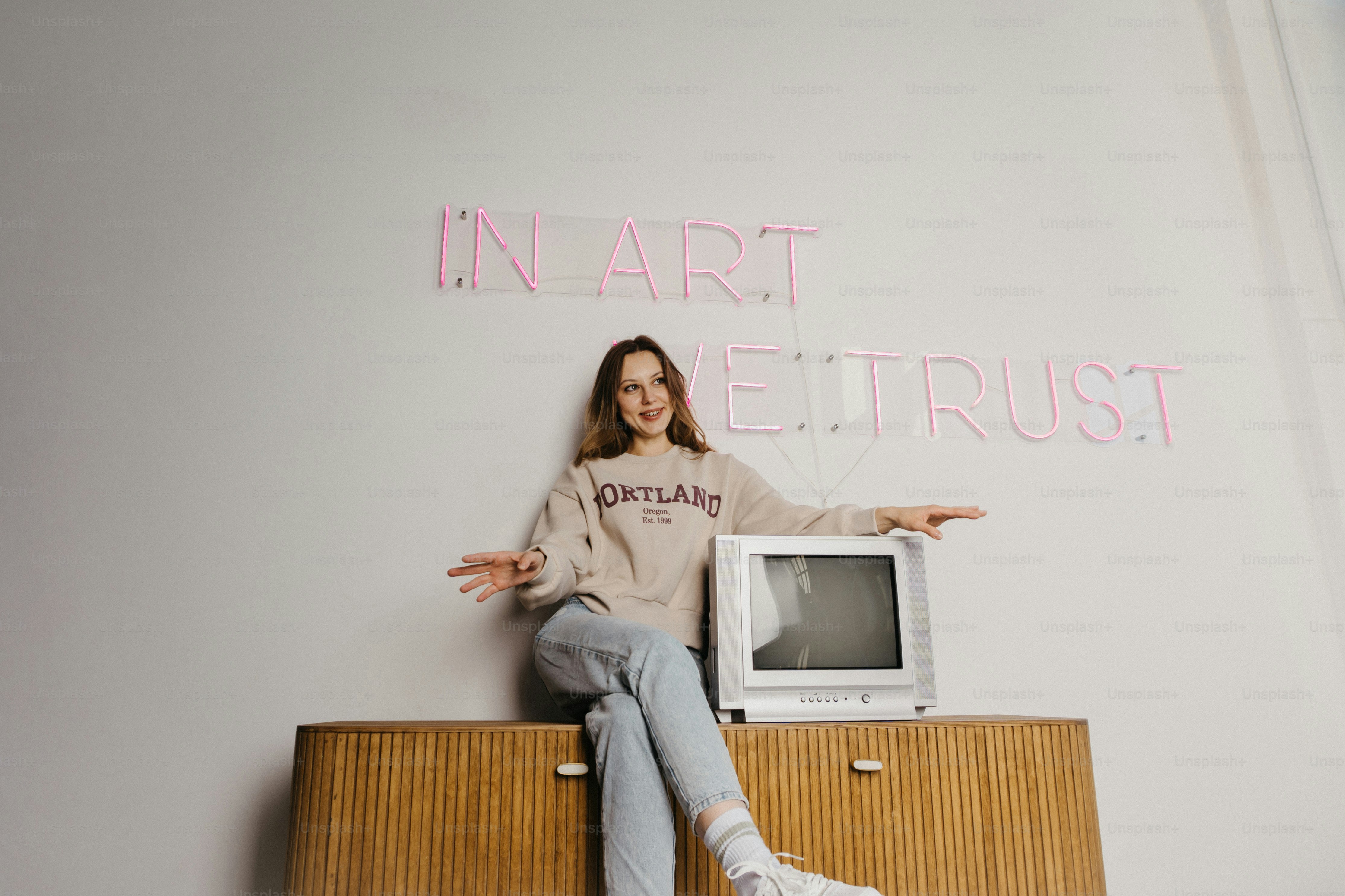 テレビの隣のキャビネットの上に座っている女性