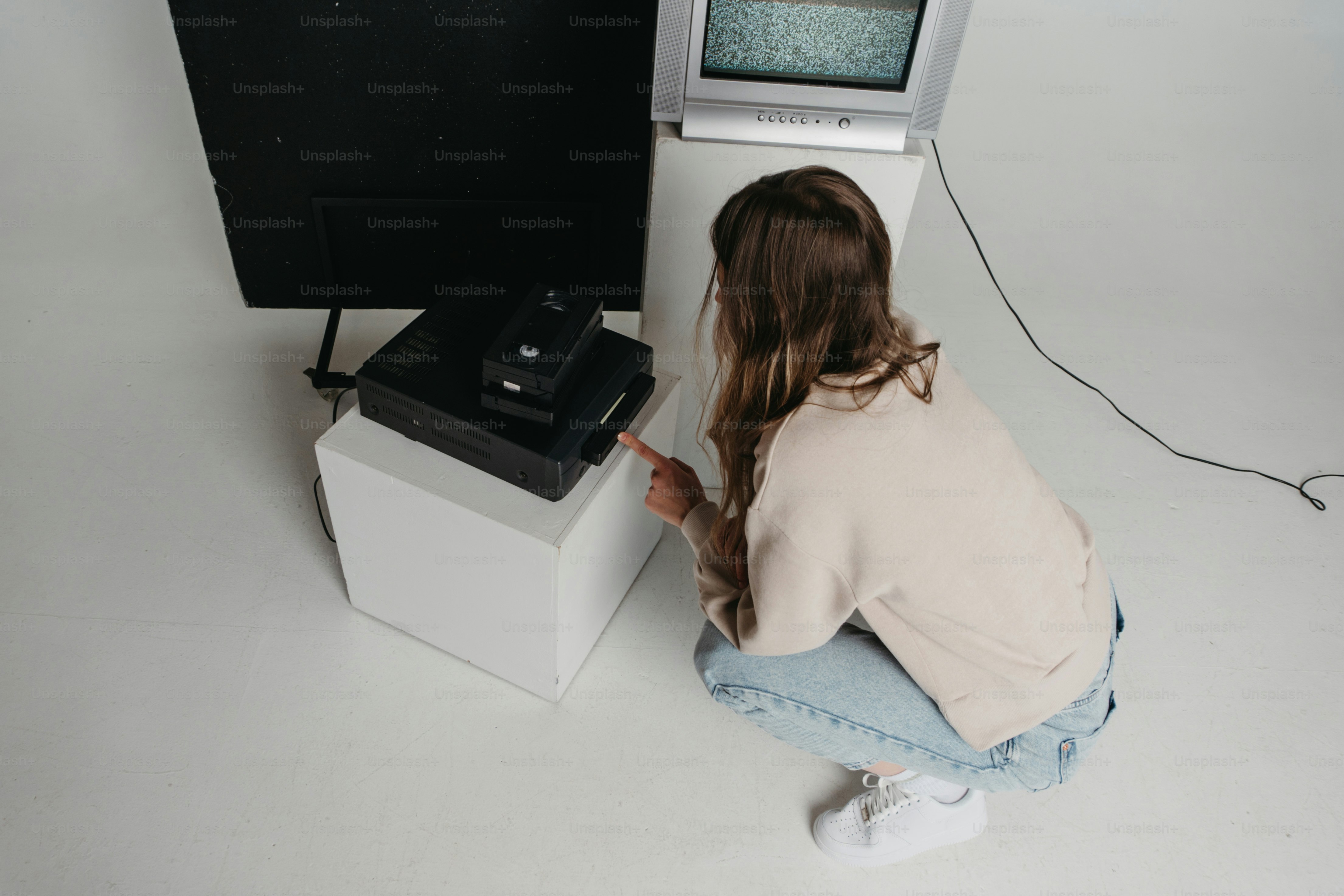 A woman sitting on the ground next to a computer