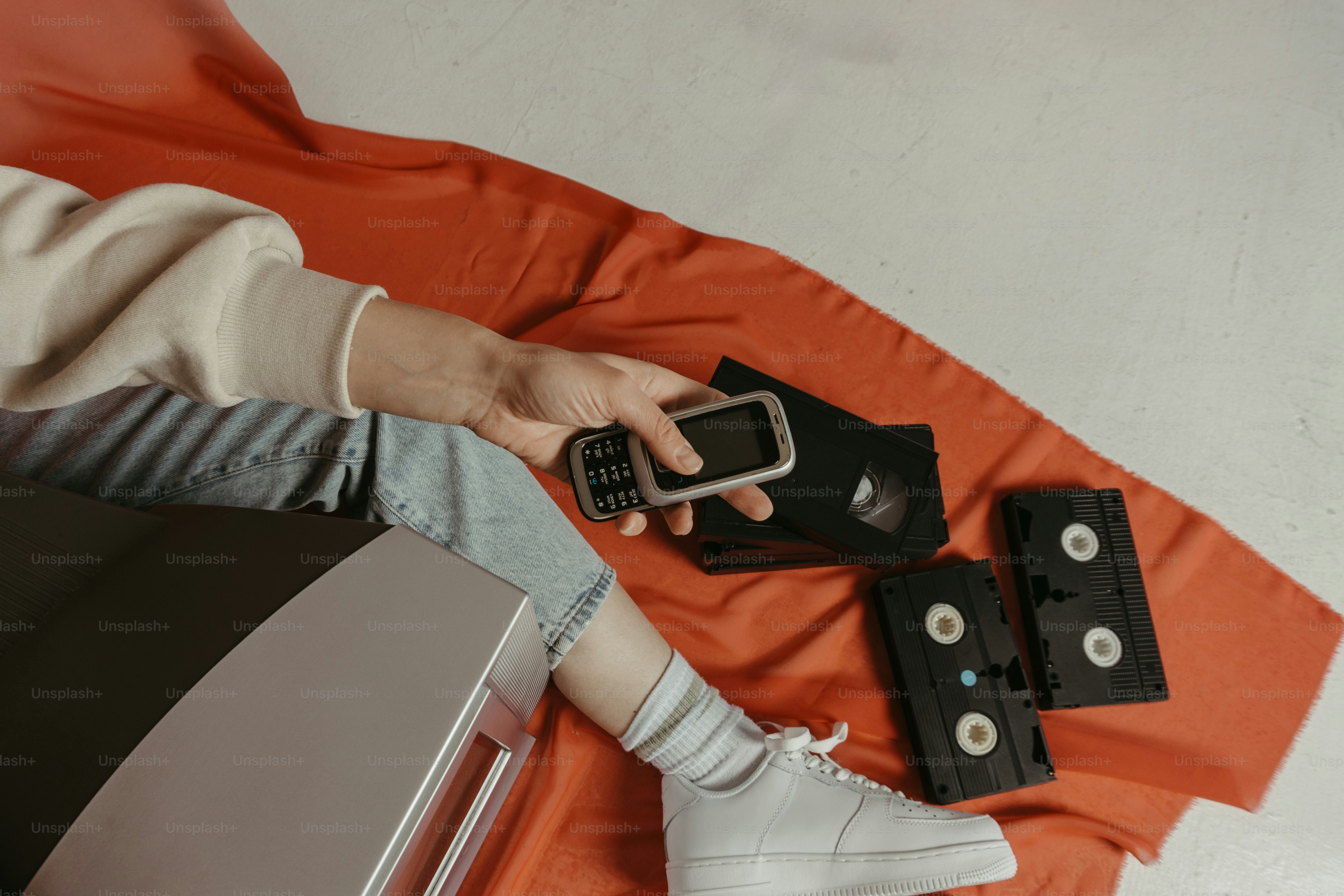 Eine Person, die auf einem Bett liegt und ein Mobiltelefon in der Hand hält