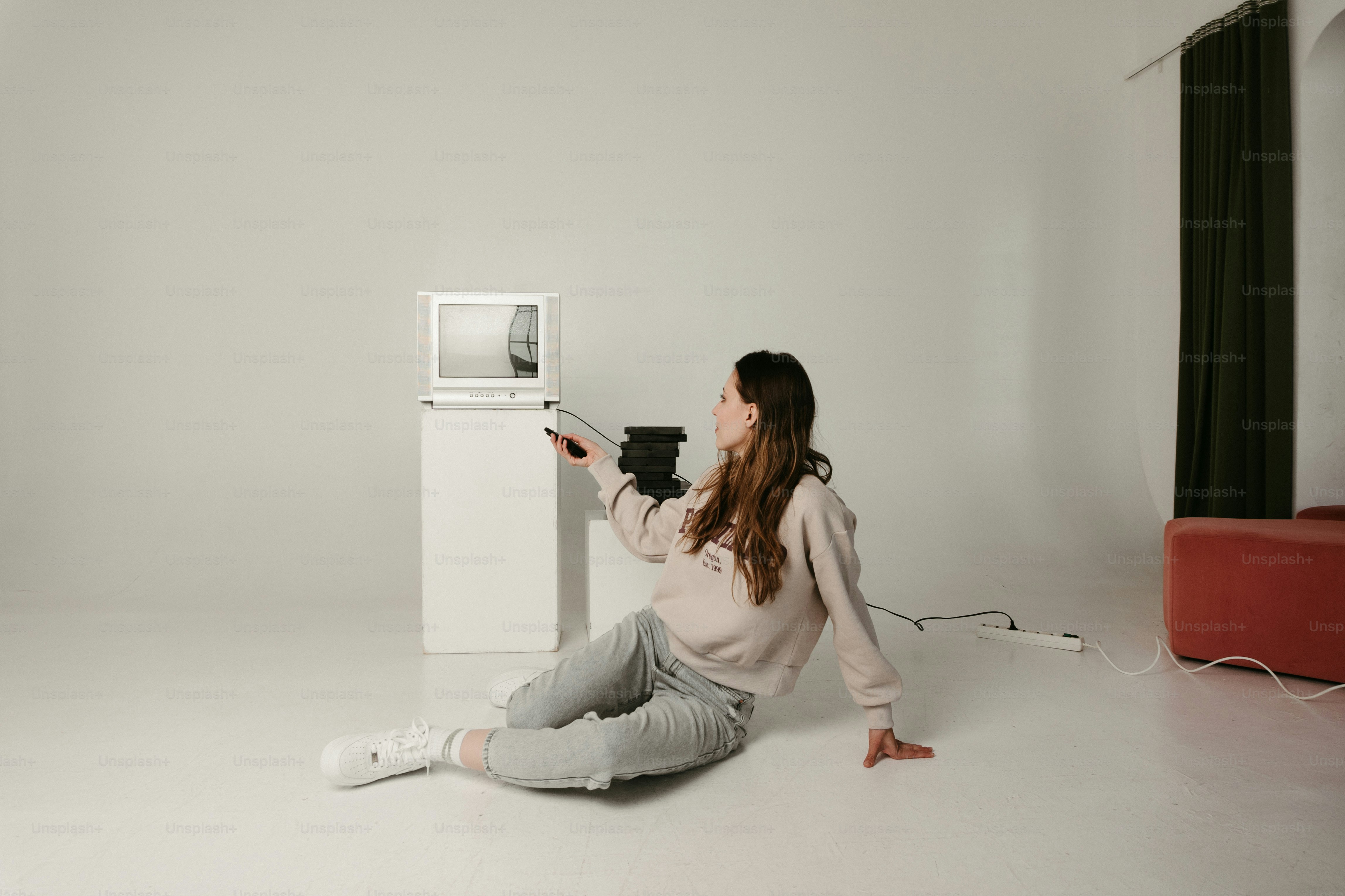 Eine Frau sitzt mit einer Mikrowelle auf dem Boden