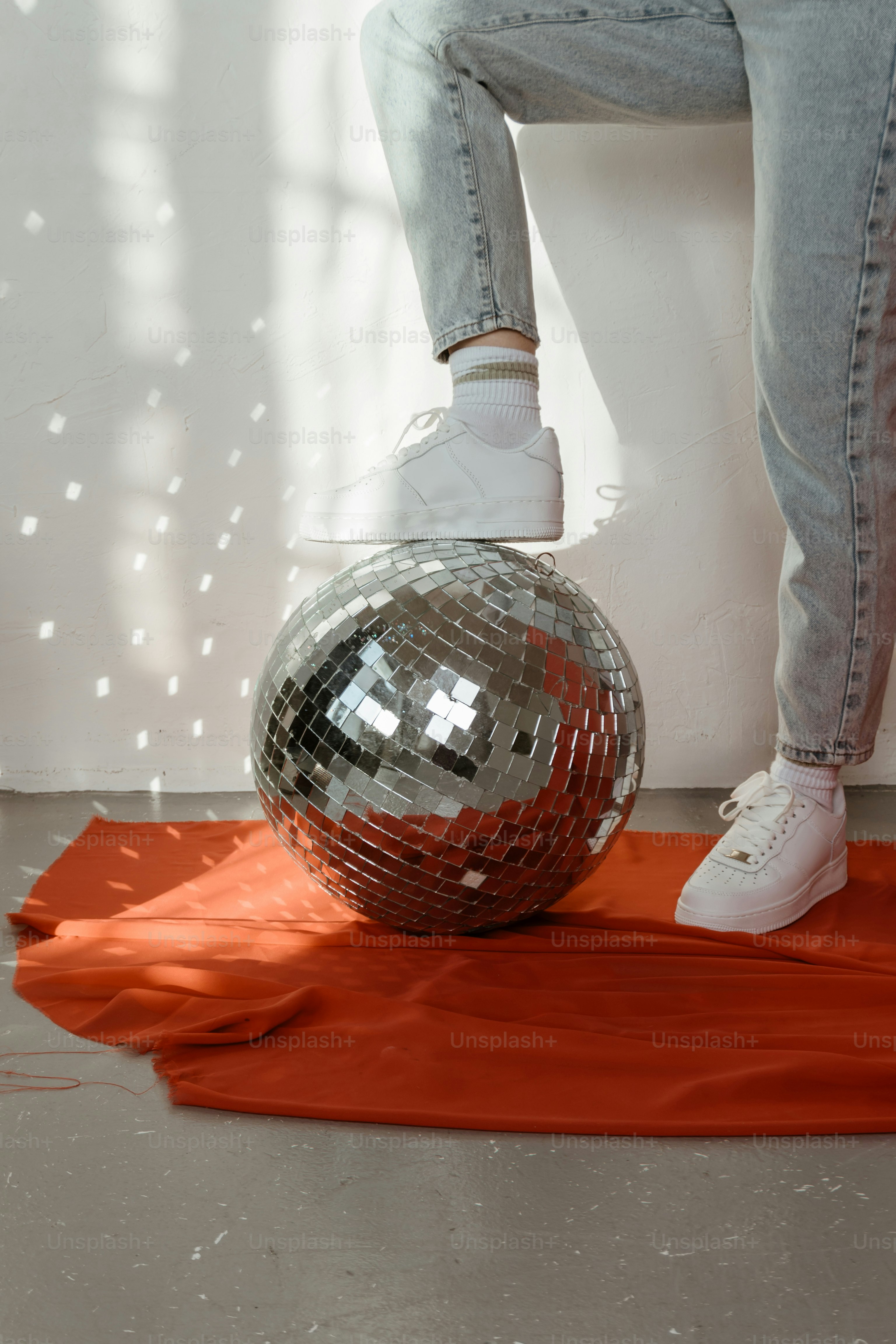 Eine Person, die auf einer glänzenden Discokugel steht