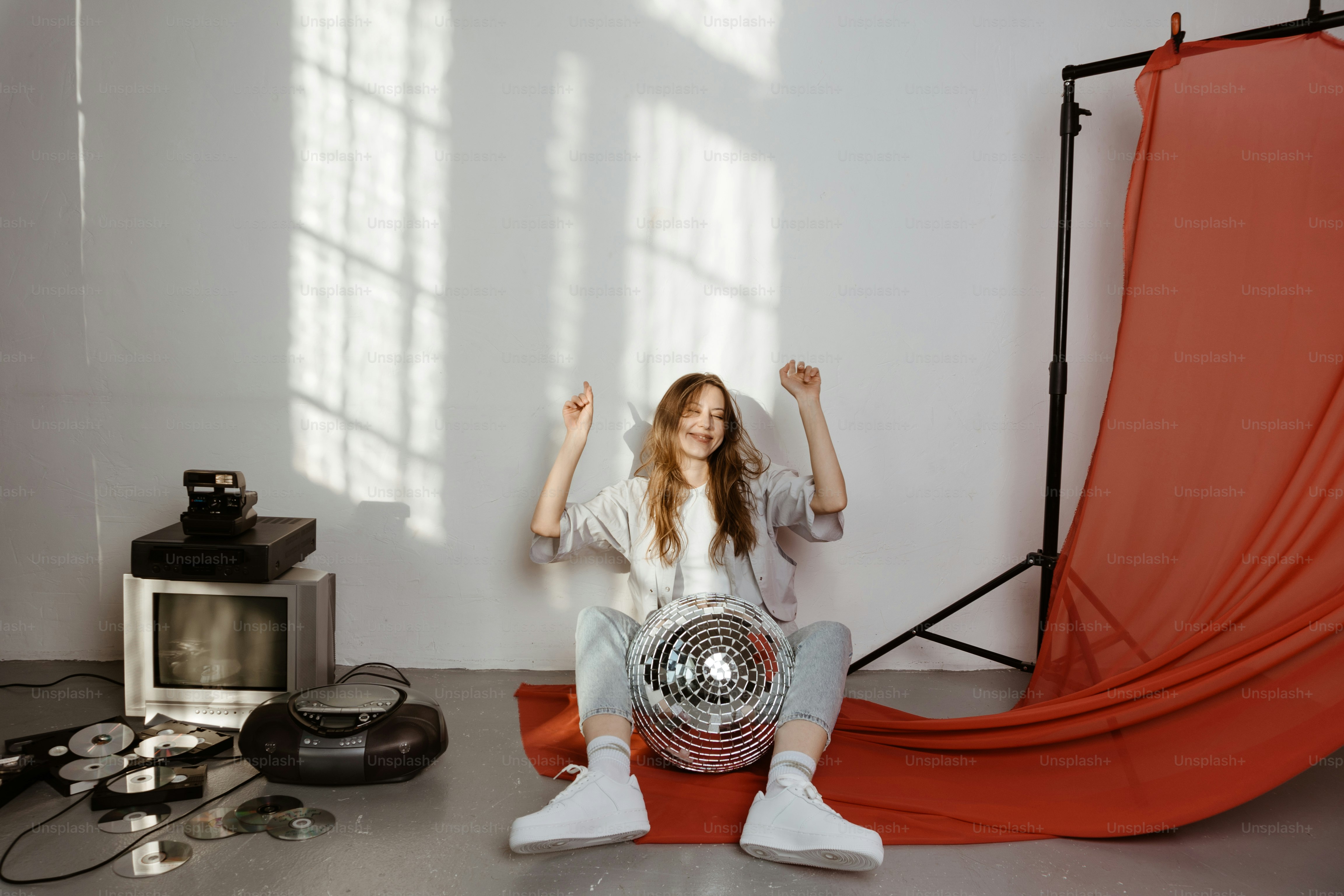 赤い背景の前で床に座っている女性