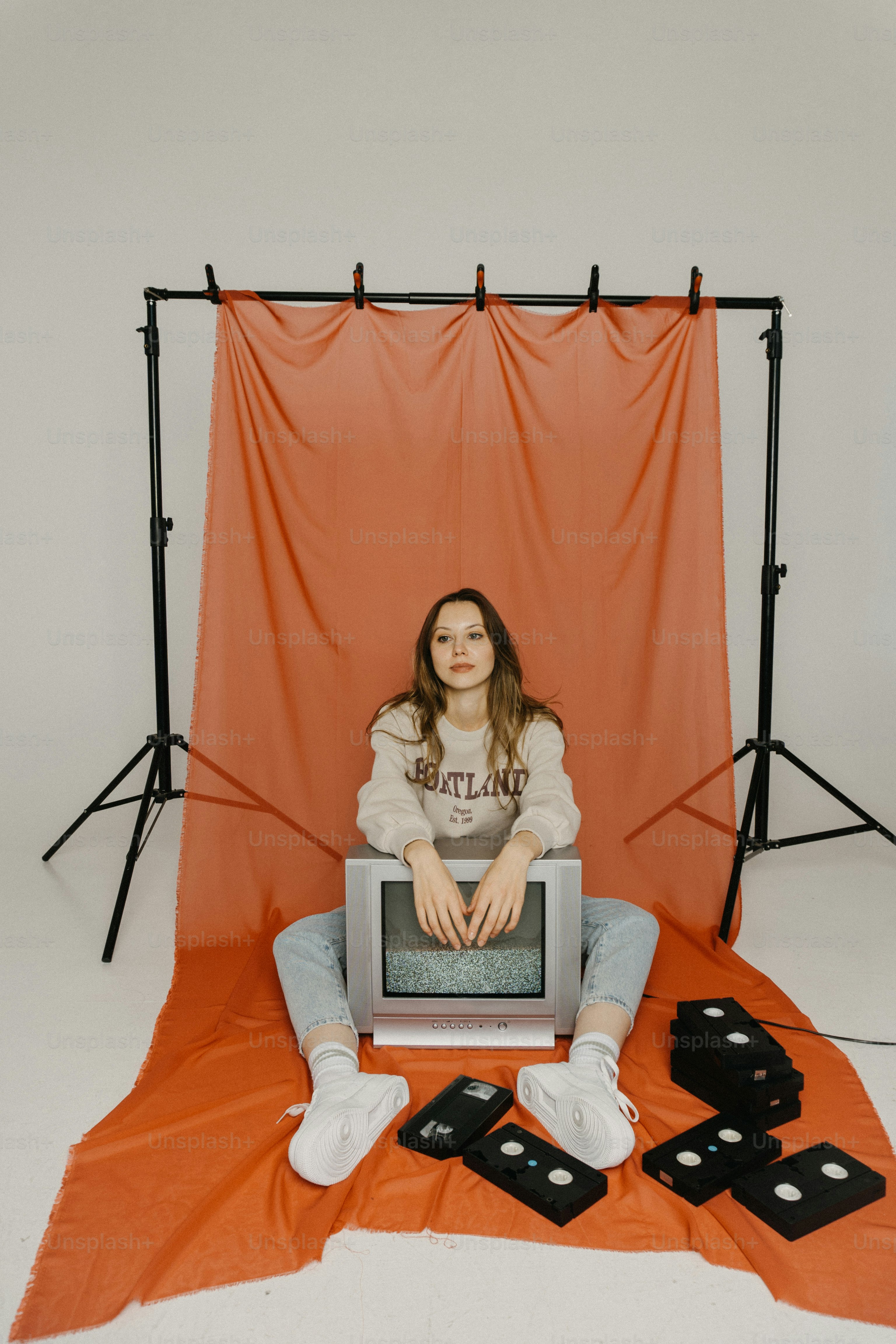 A woman sitting on a chair in front of a TV