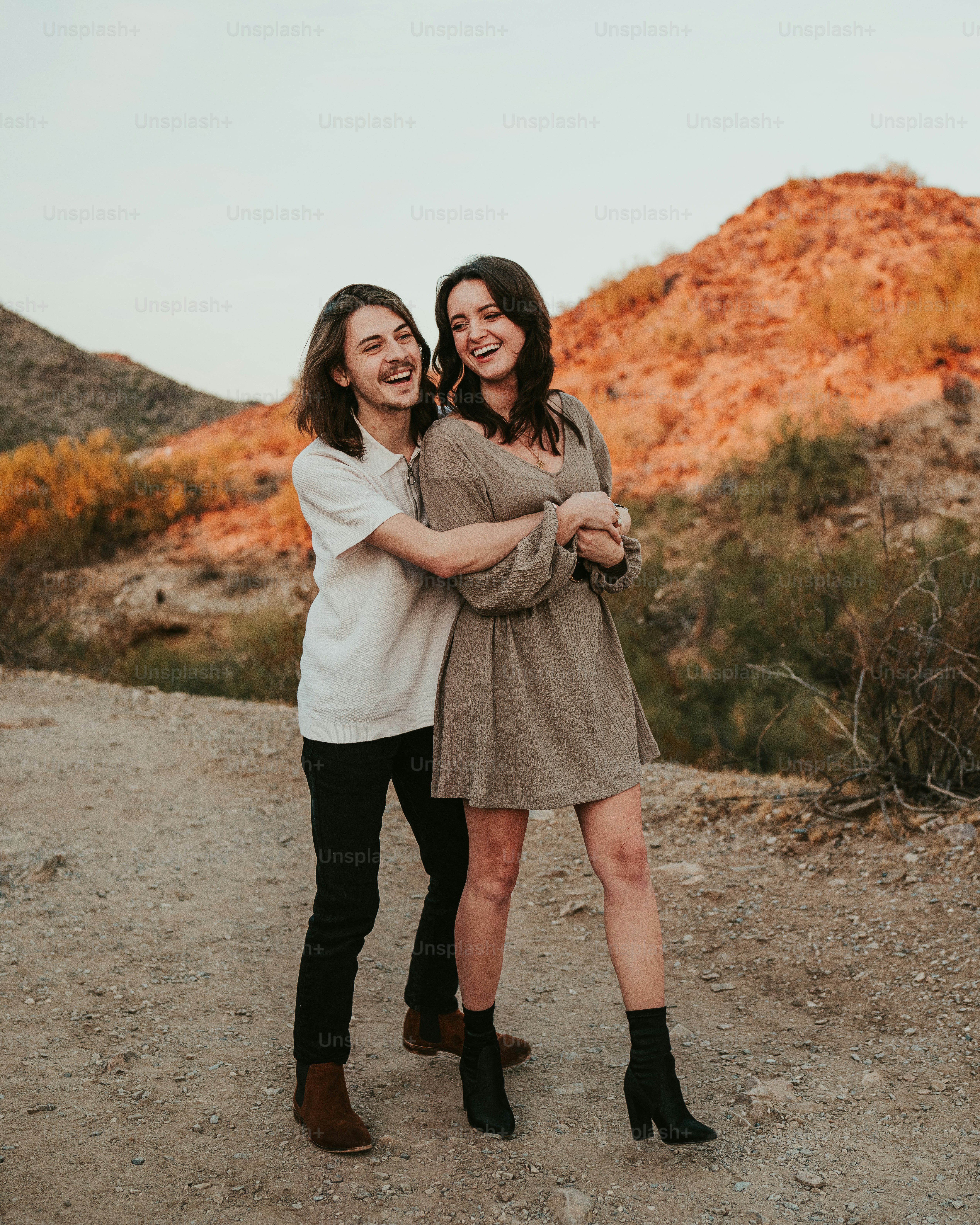 A couple of women standing next to each other on a dirt road