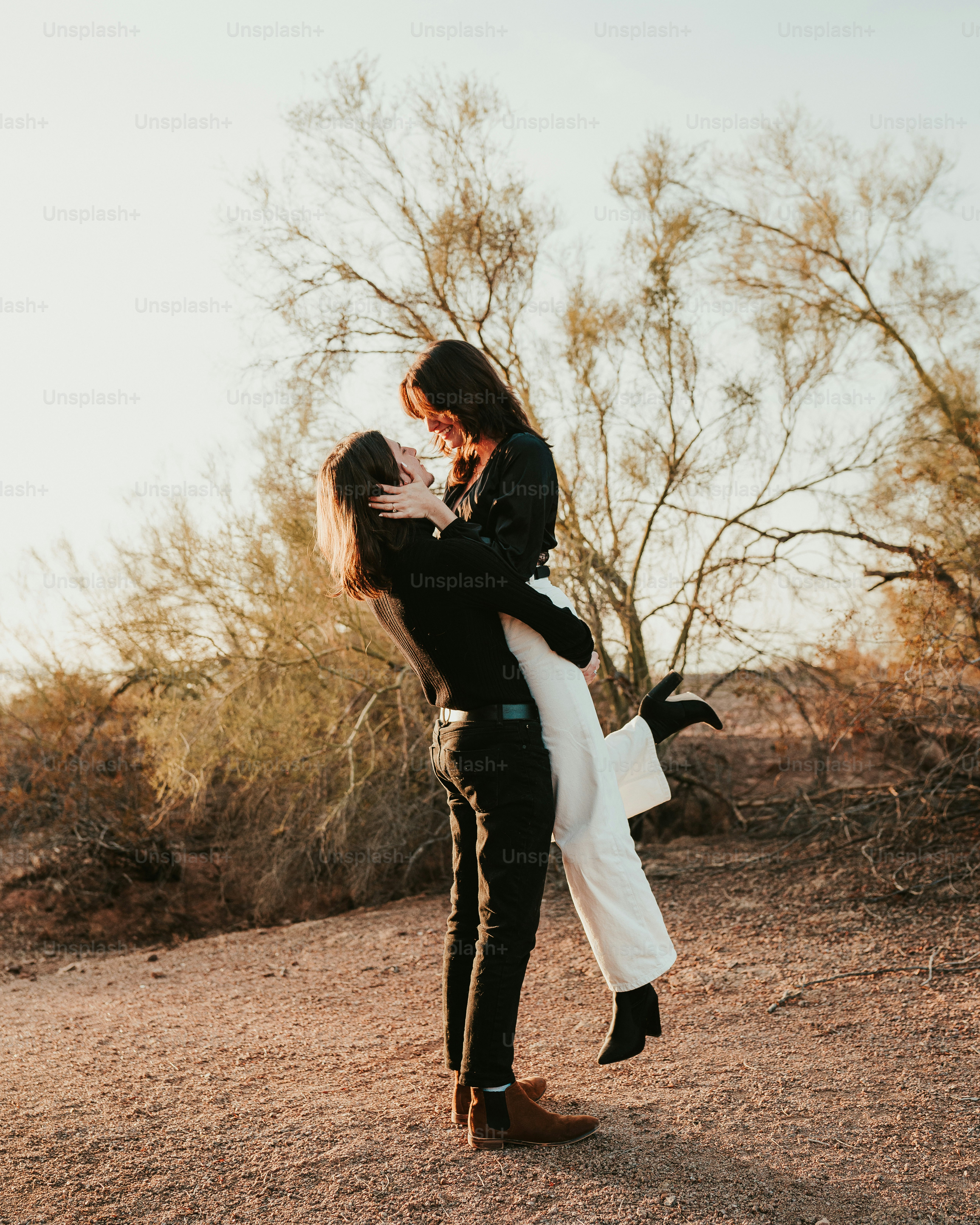 A man holding a woman in the desert