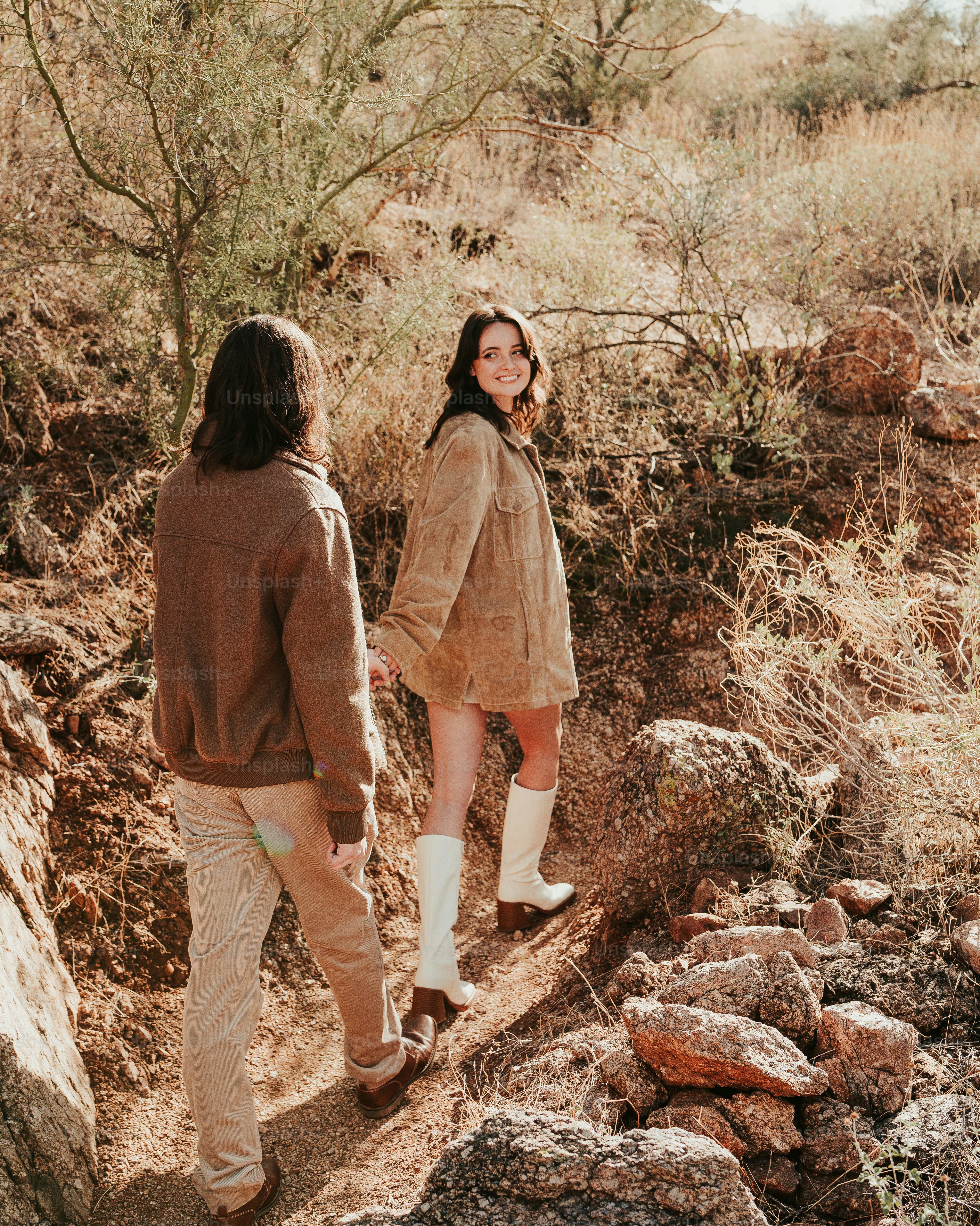 A couple of people standing on a dirt road