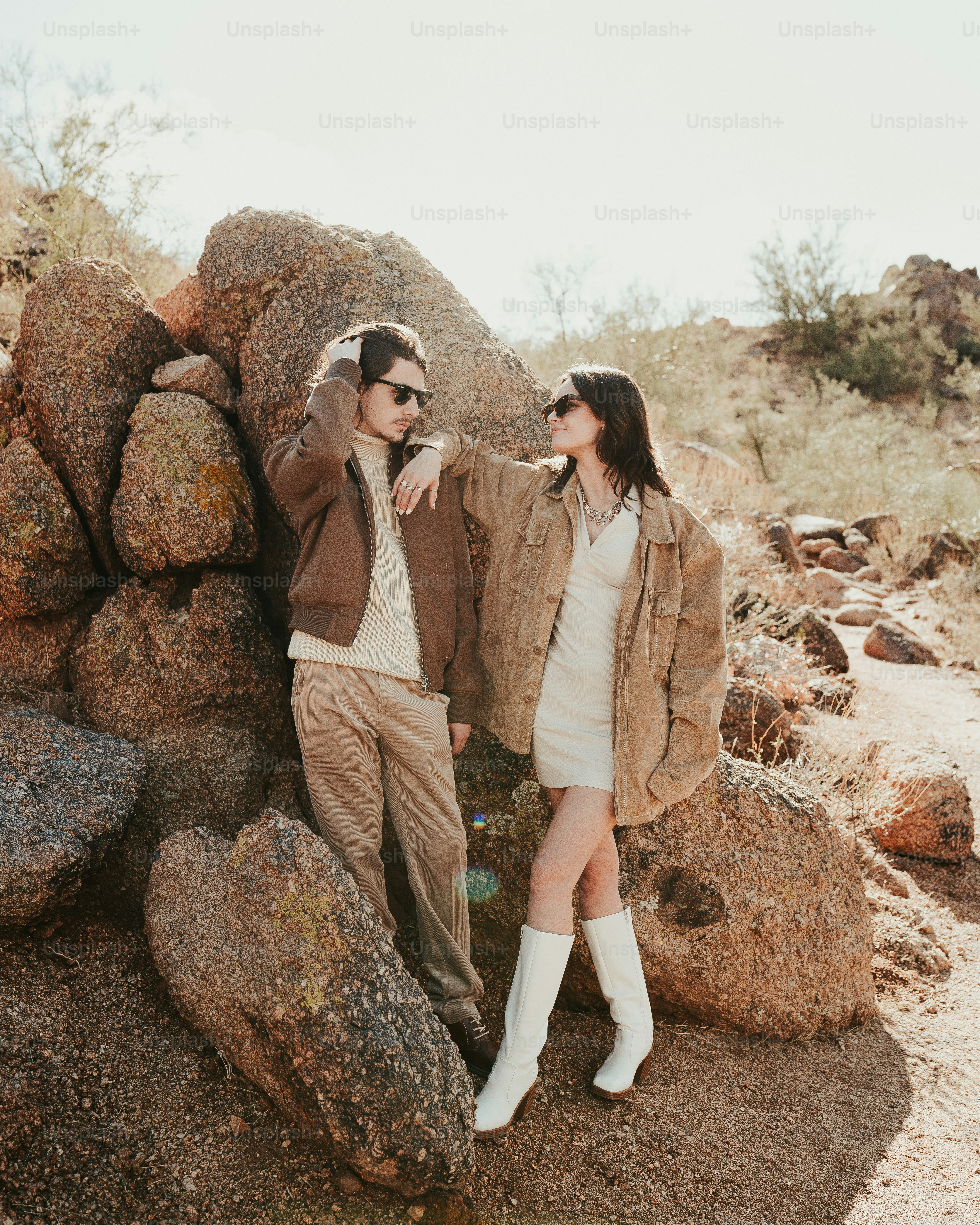 A man and a woman standing next to a pile of rocks