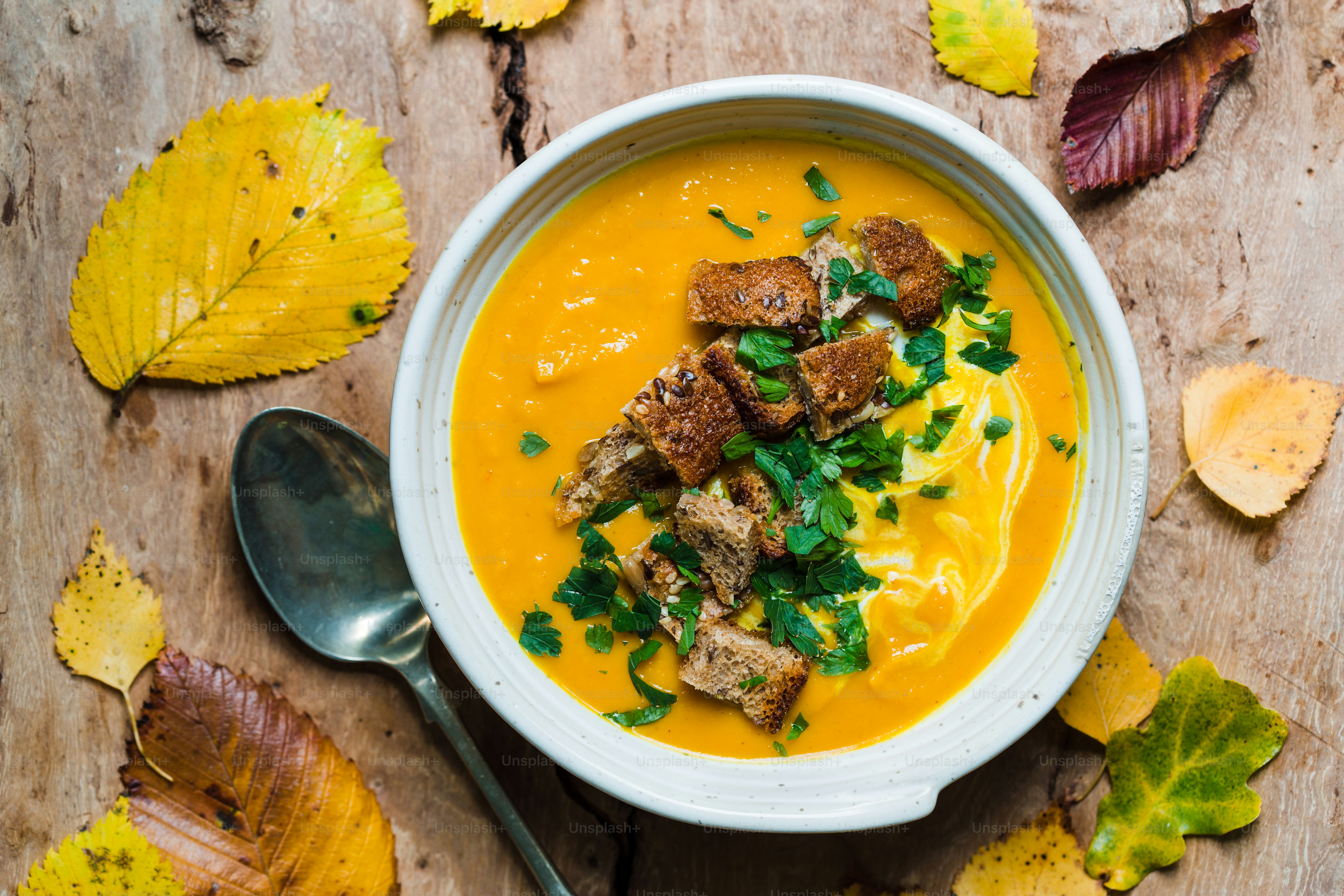 A bowl of soup with a spoon on a table