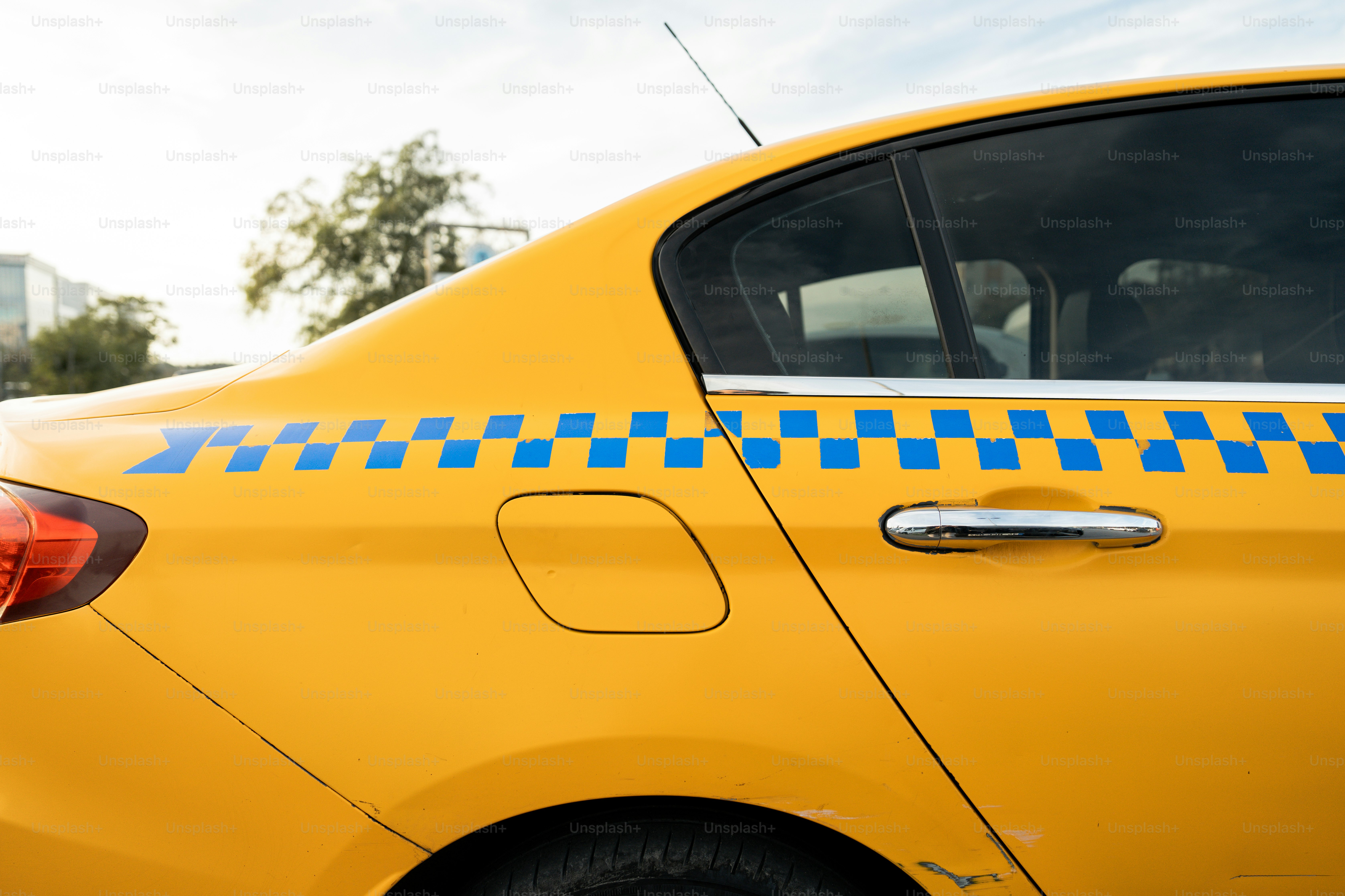 A close up of a yellow car with a blue and white checkered decal