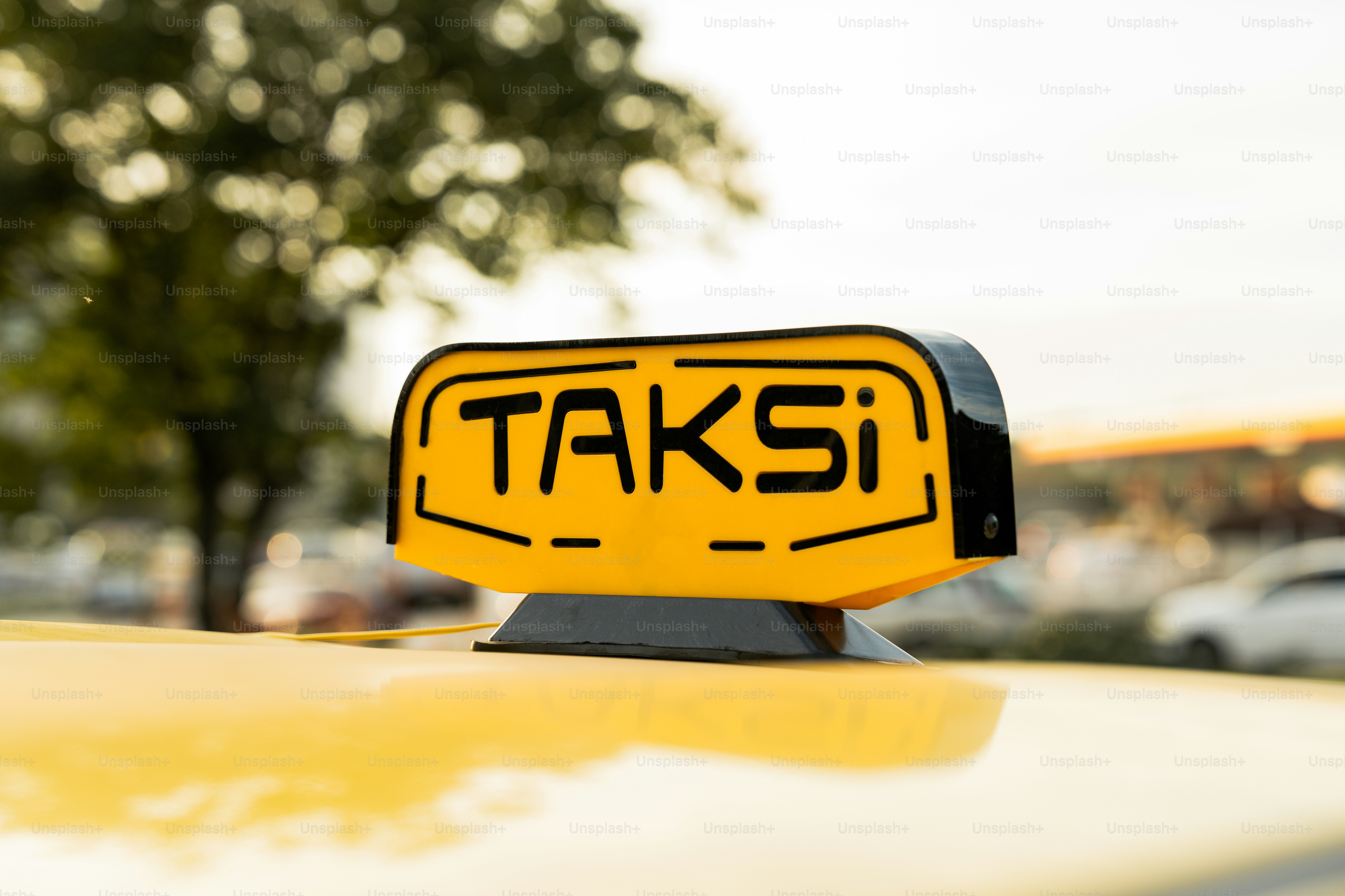 Un cartello giallo del taxi seduto sopra un'auto gialla