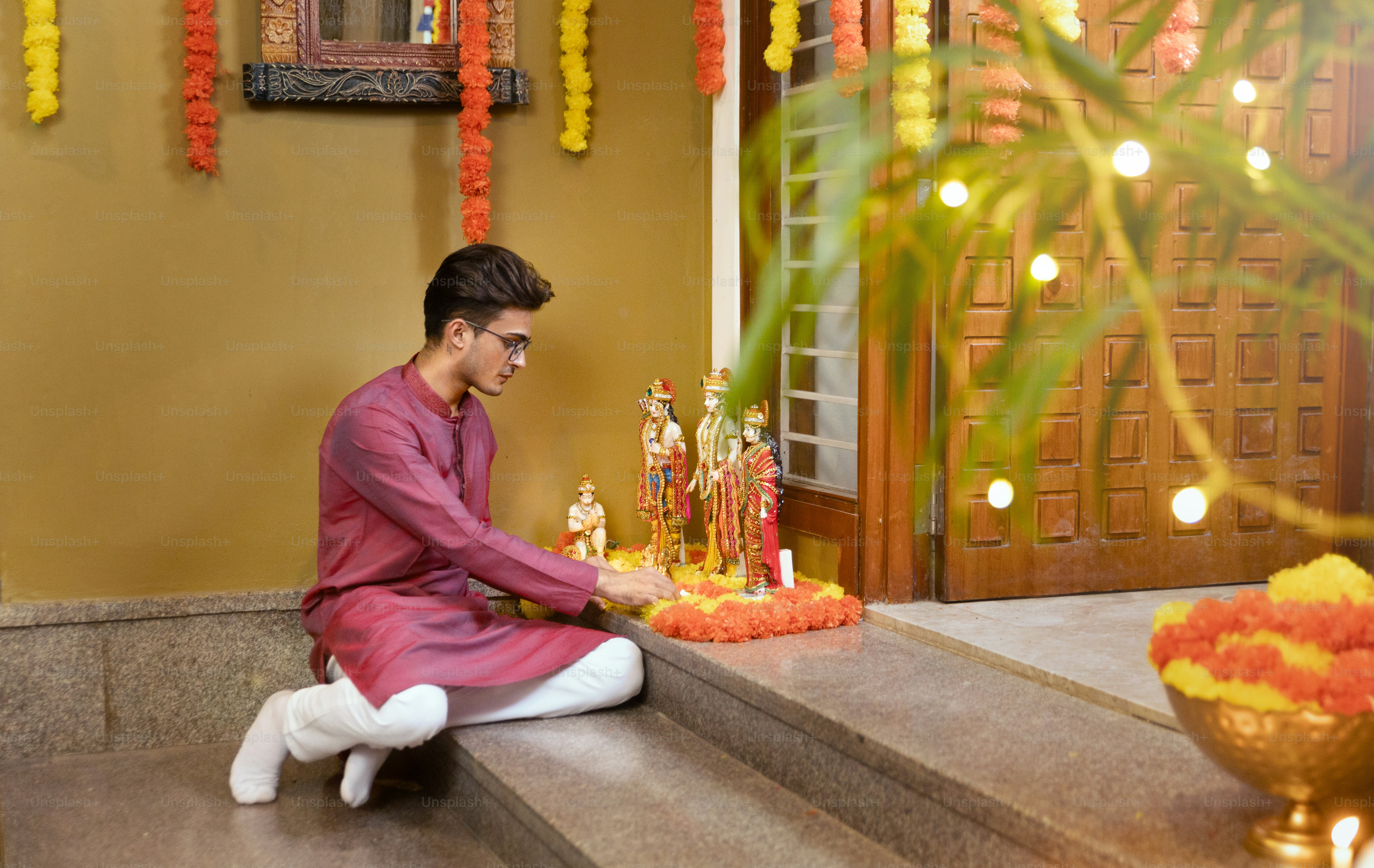 A man sitting on a step in front of a potted plant