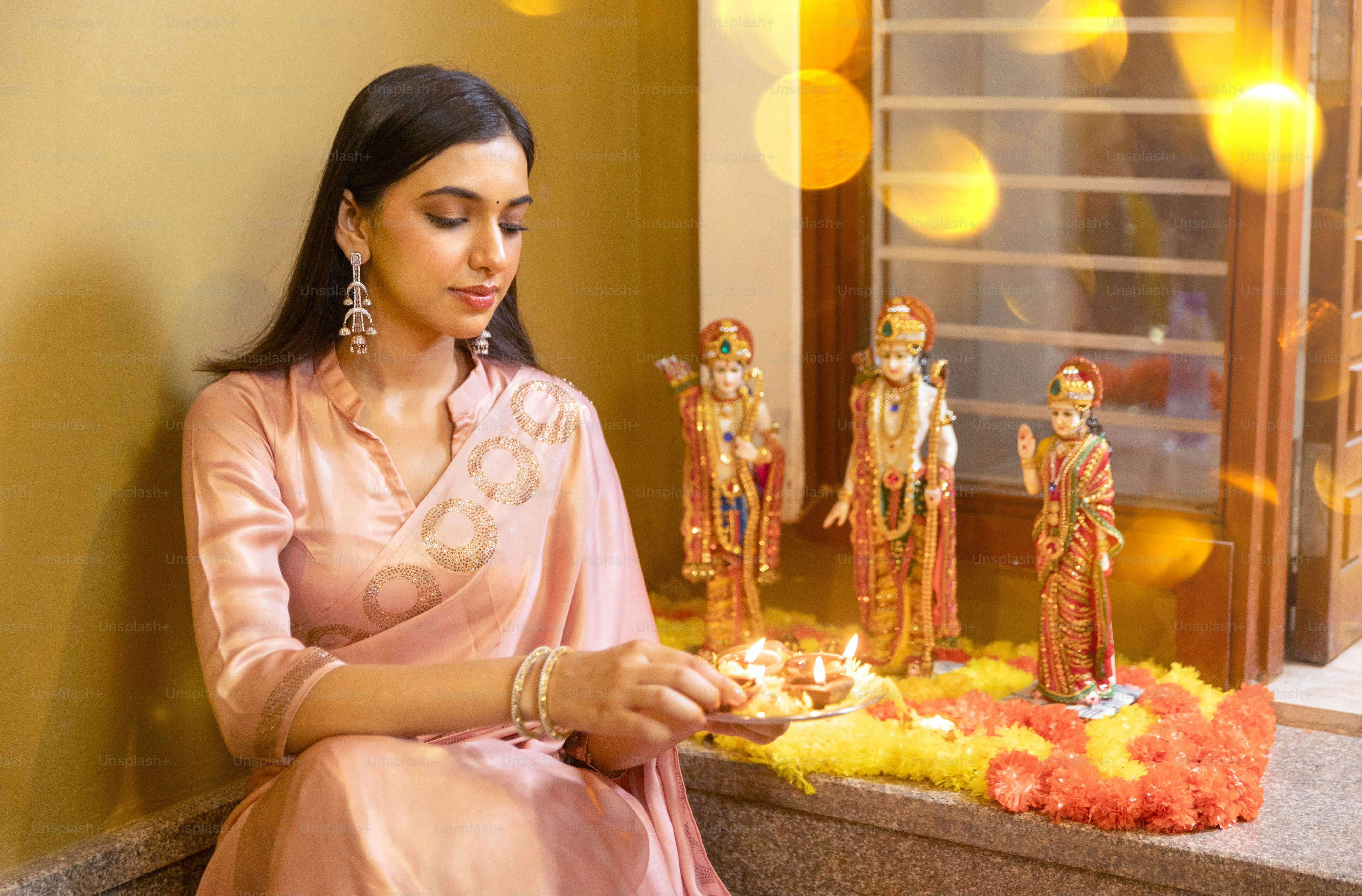 A woman in a pink sari sitting on a ledge