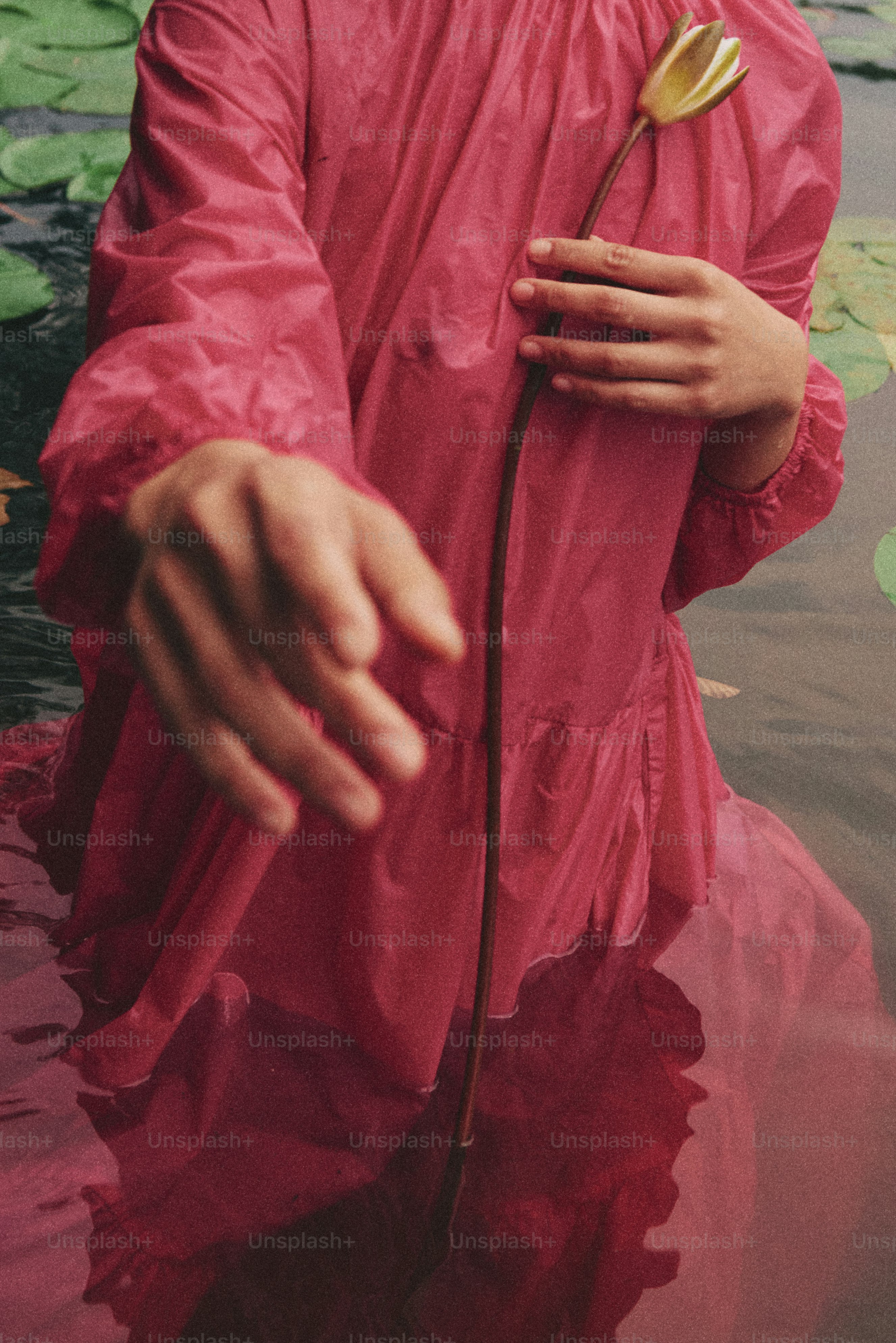 A man in a red raincoat standing in a body of water