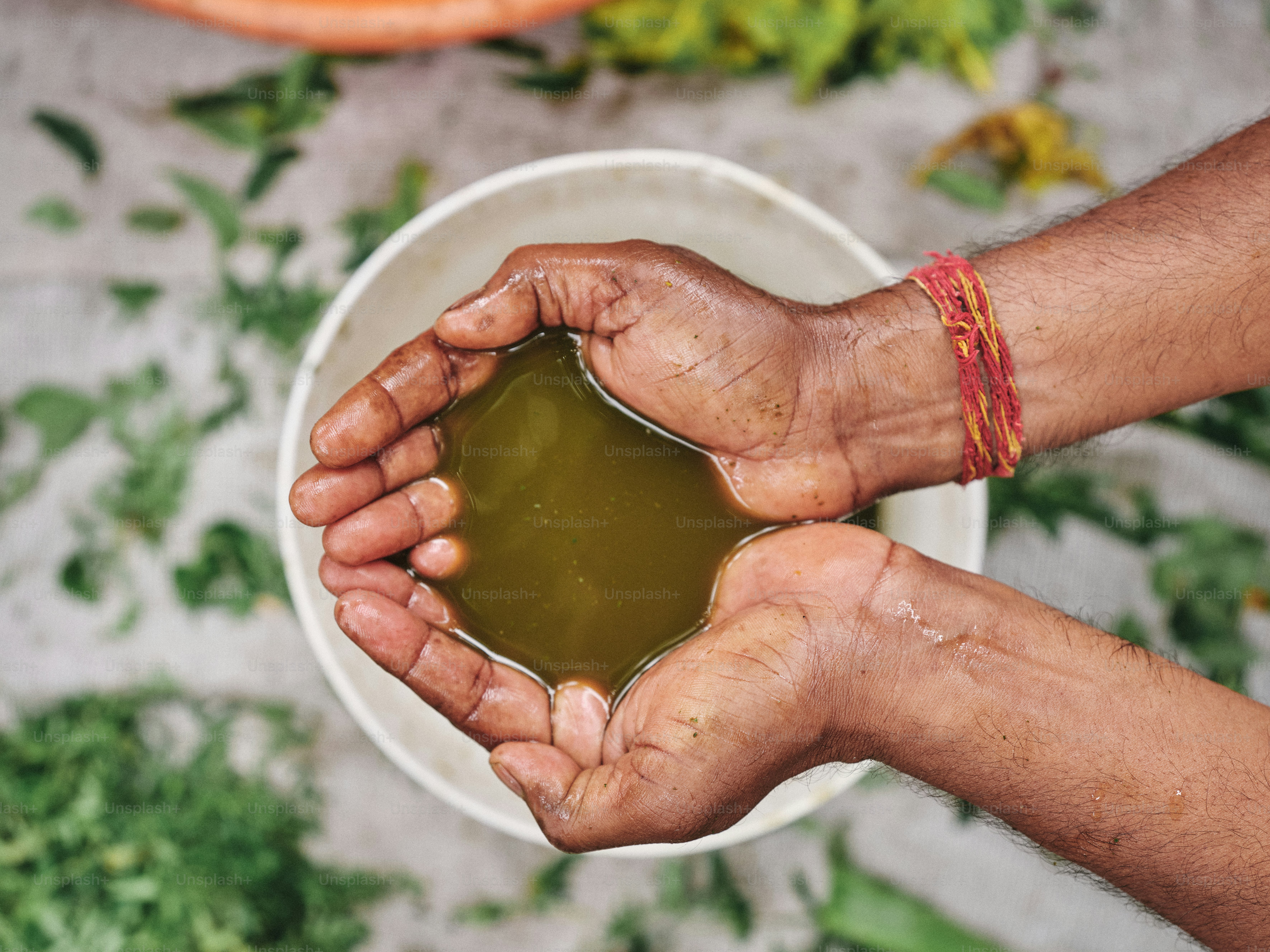 A person holding a bowl of green liquid