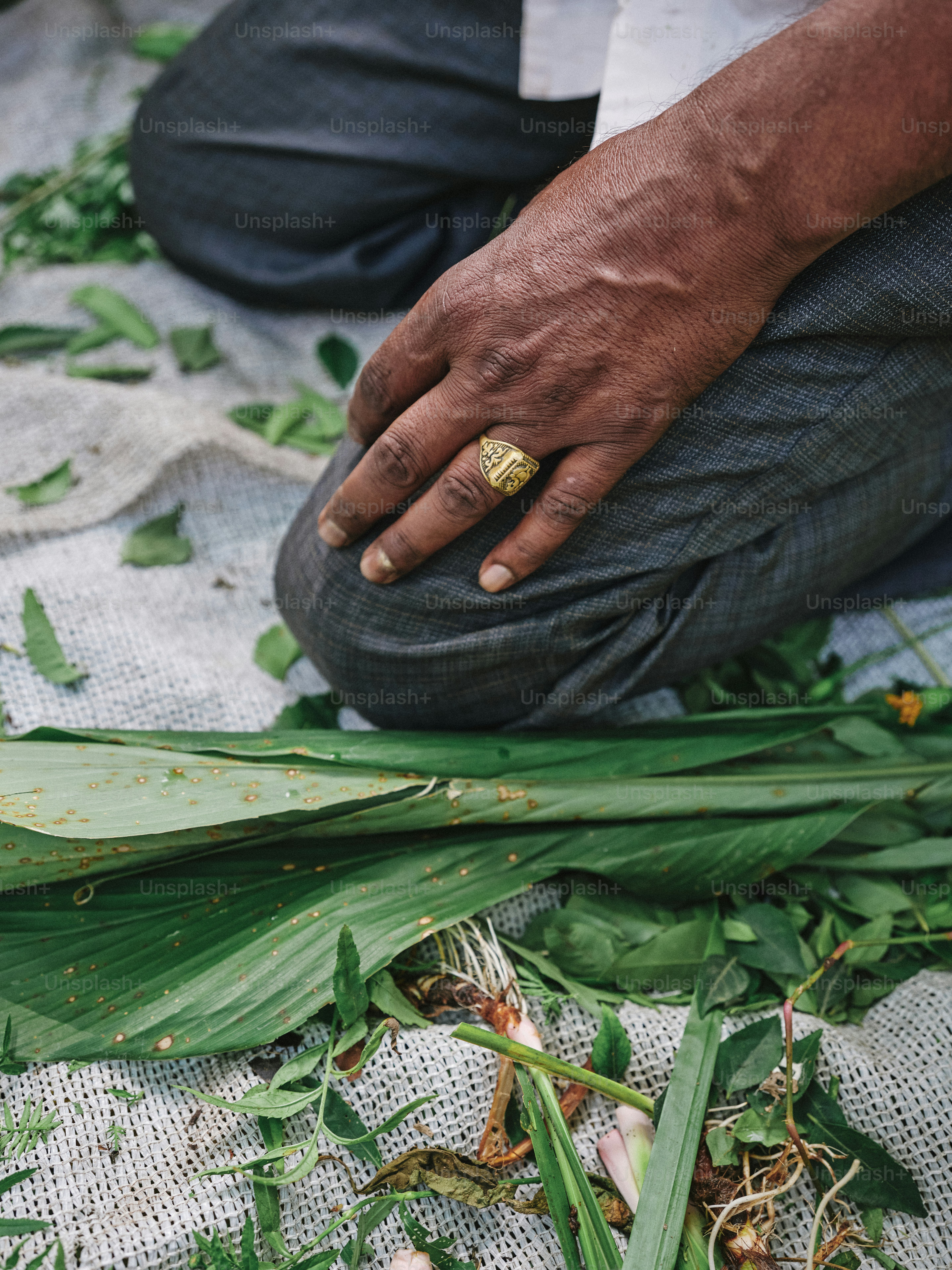 Ein Mann kniet neben einem Laubhaufen