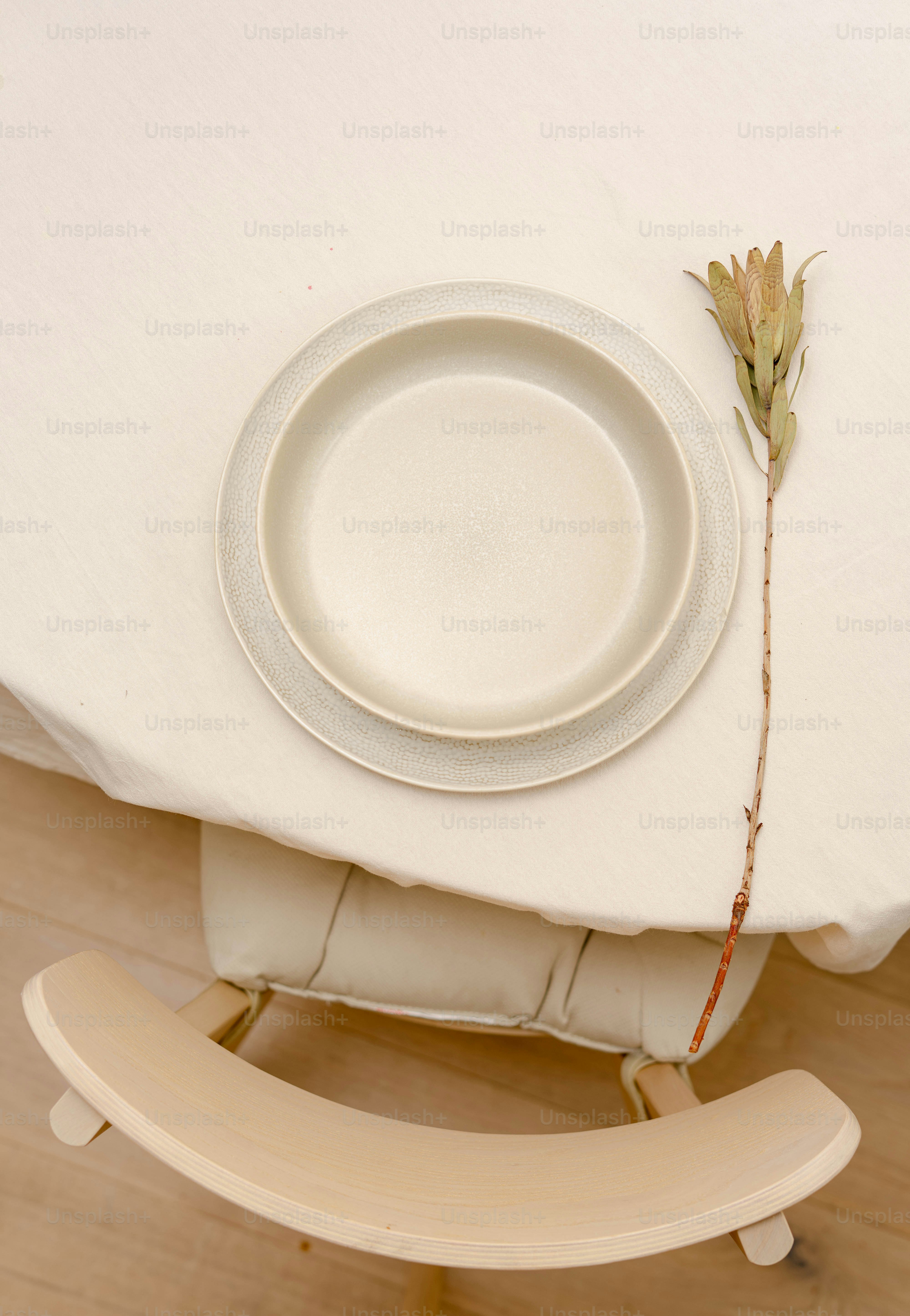 A table with a plate and a flower on it