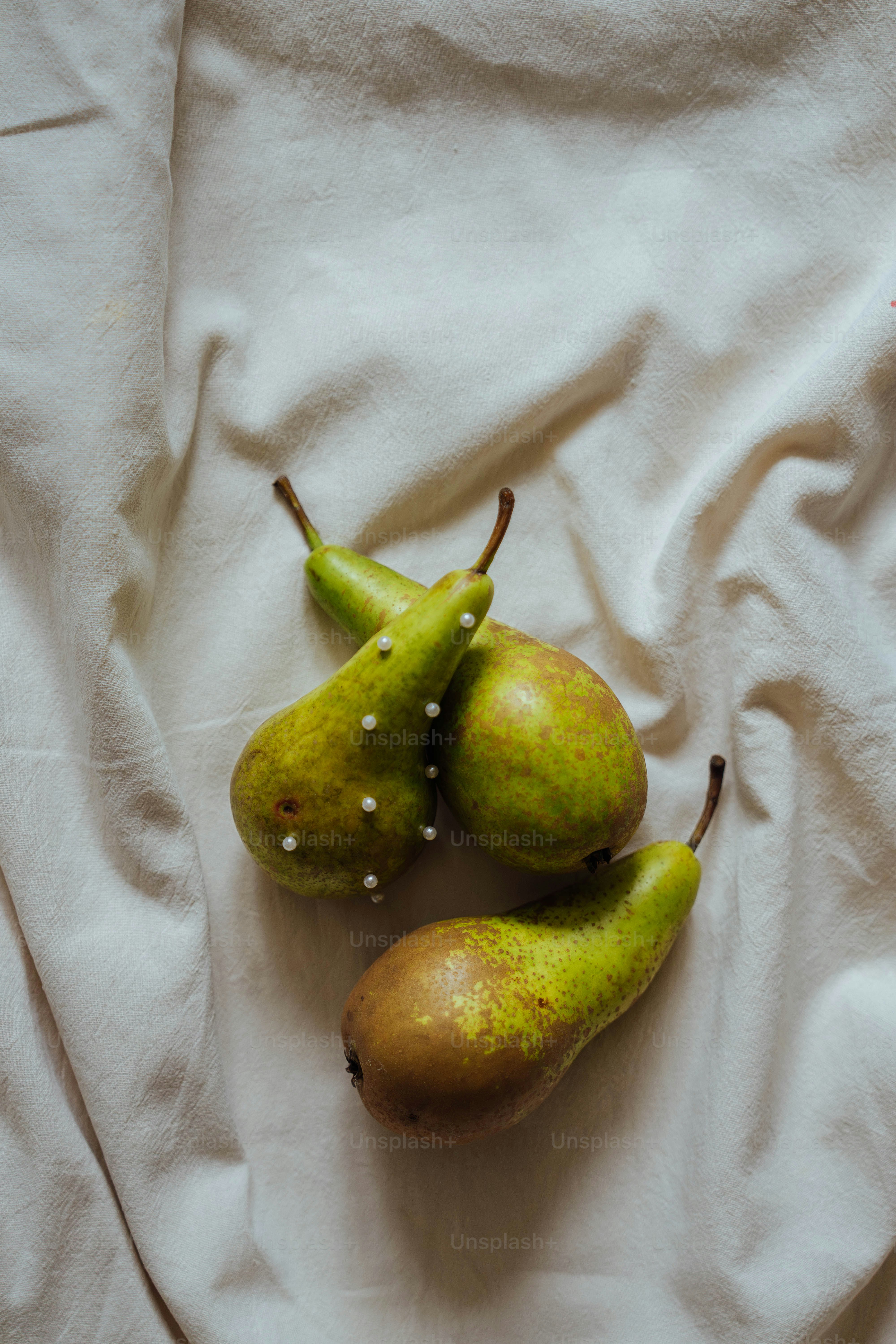 Un par de peras sobre una sábana blanca