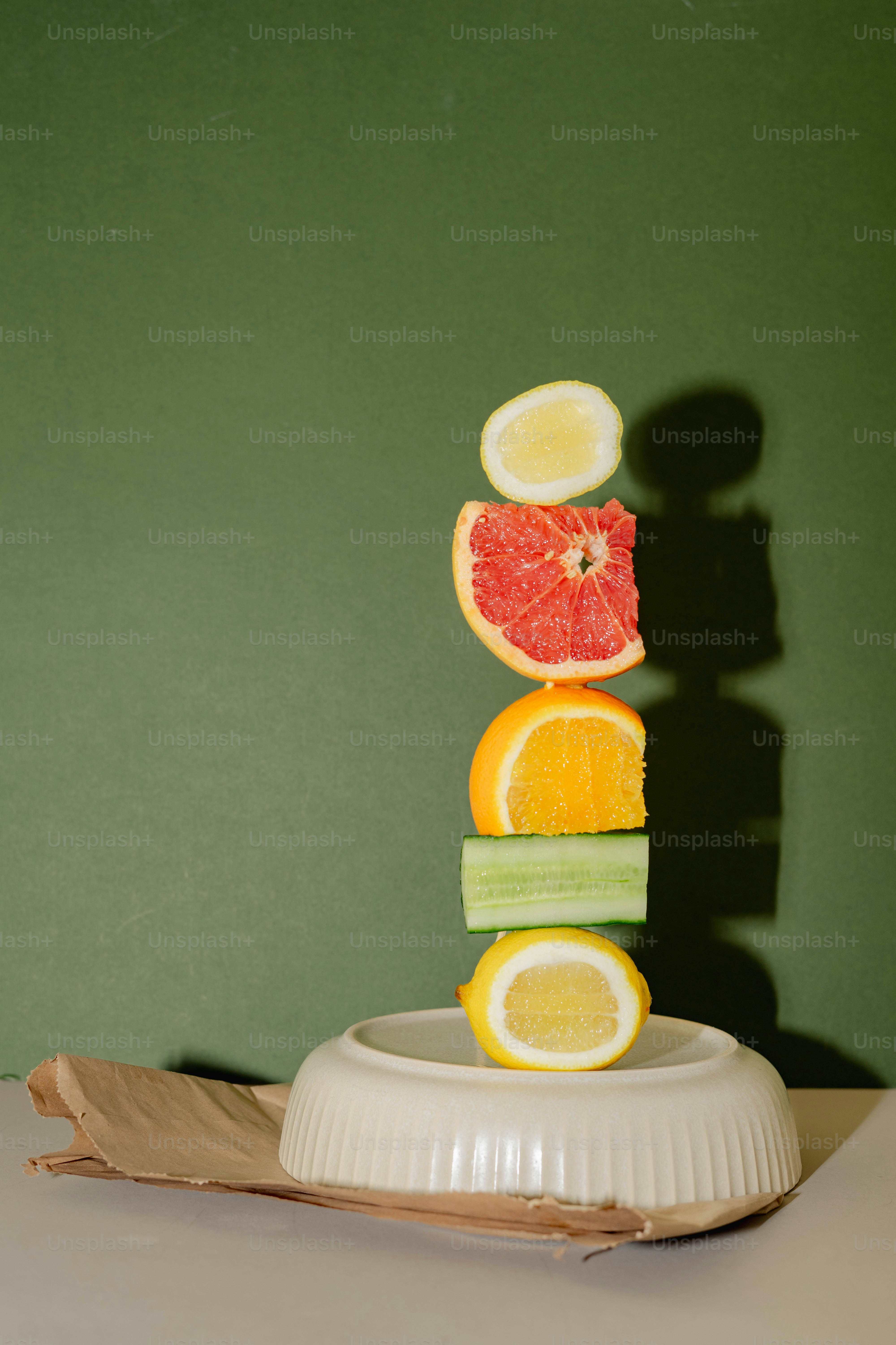 A stack of slices of fruit sitting on top of a white plate