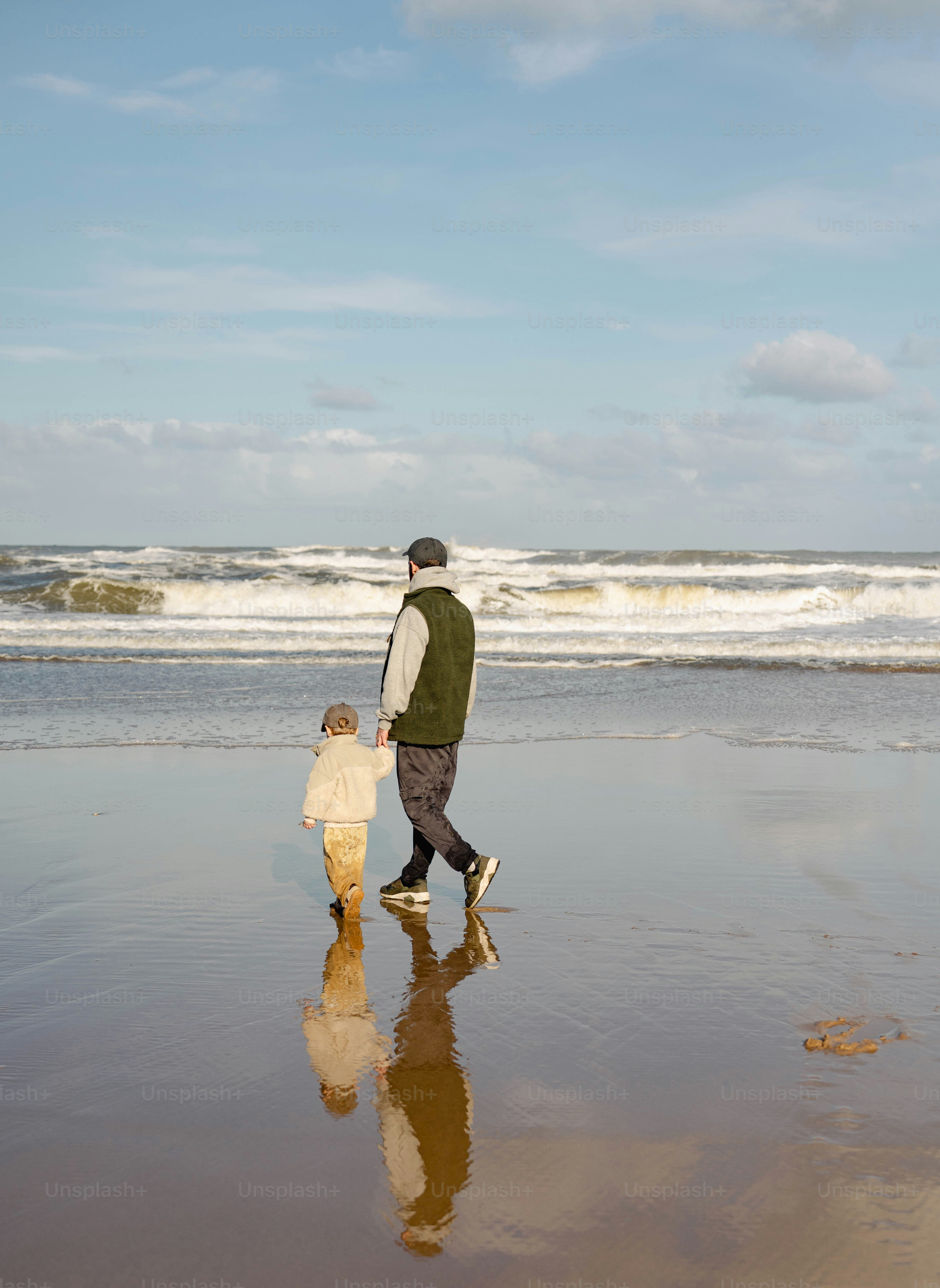 Un hombre y un niño caminando por la playa