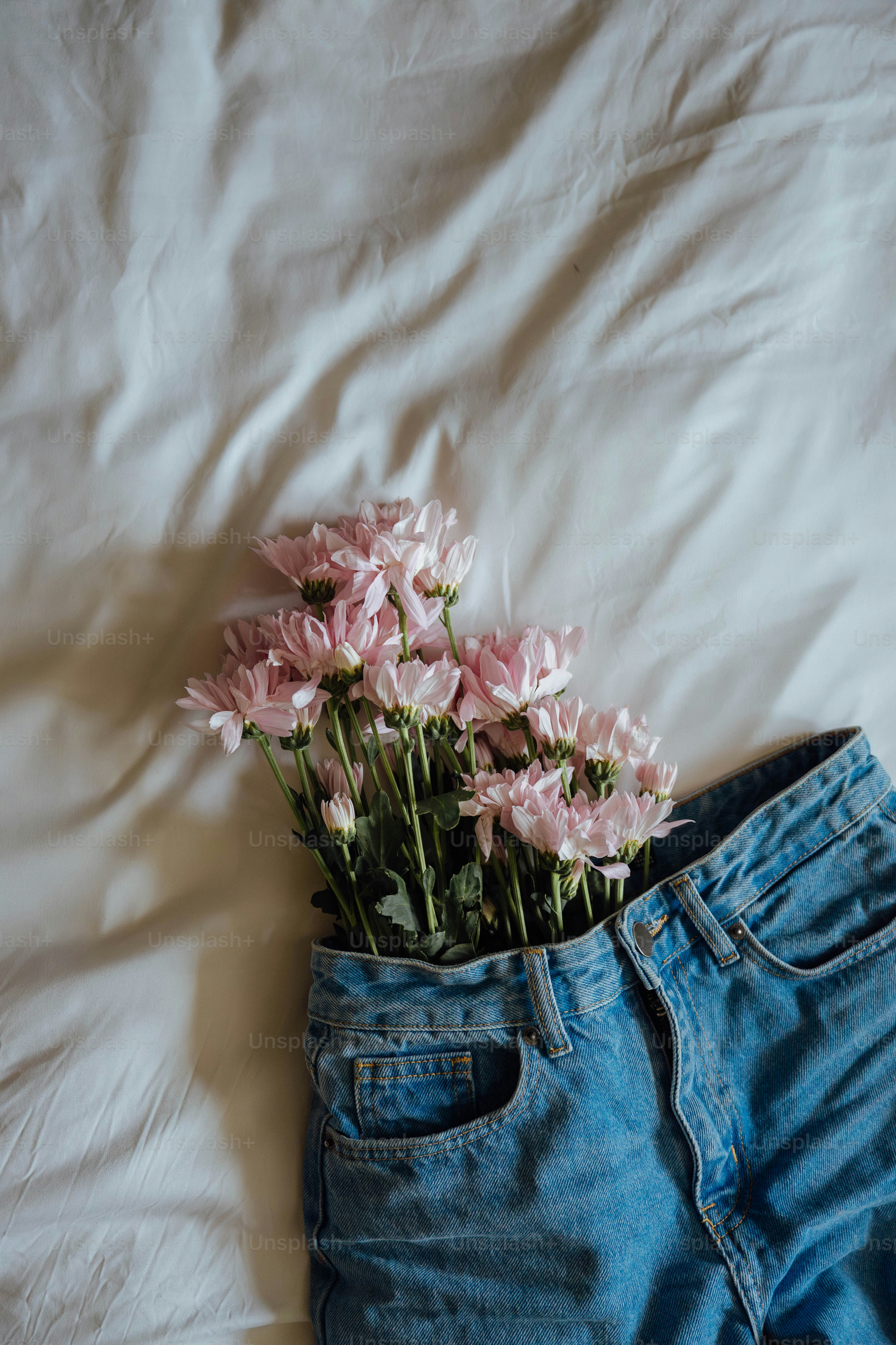 A pair of jeans with flowers sticking out of it