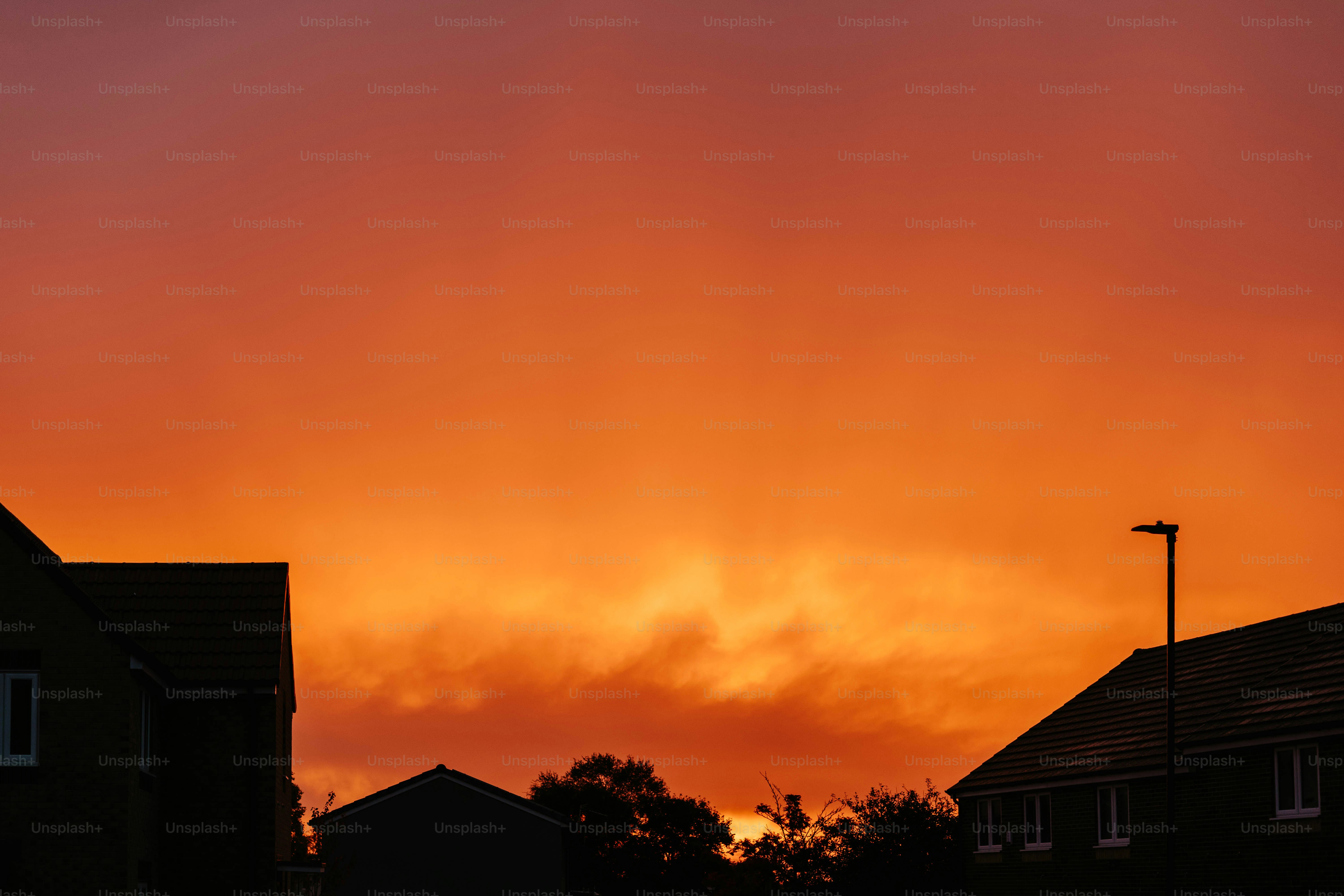 A red sky is seen over some houses