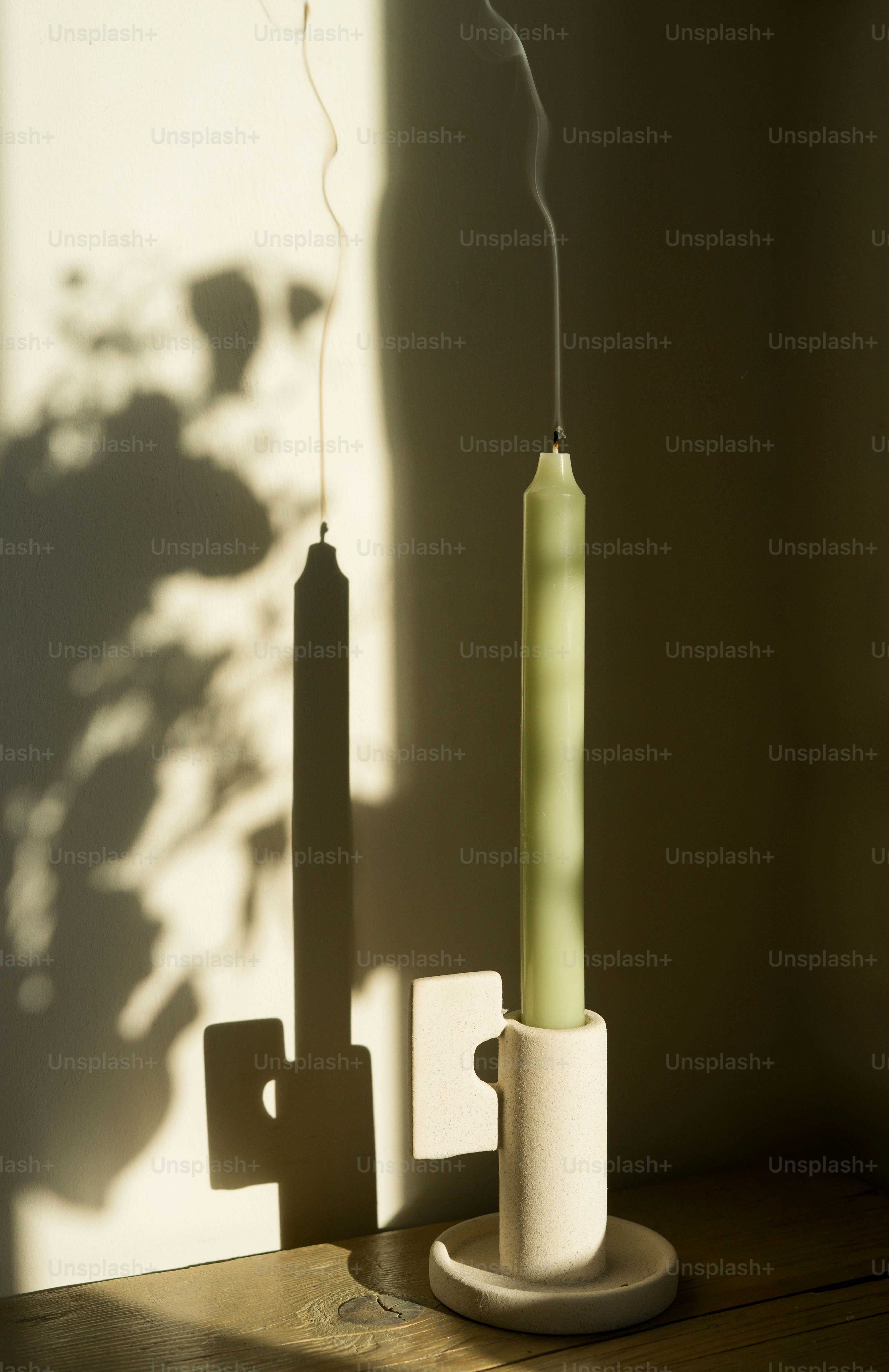 A green candle sitting on top of a wooden table