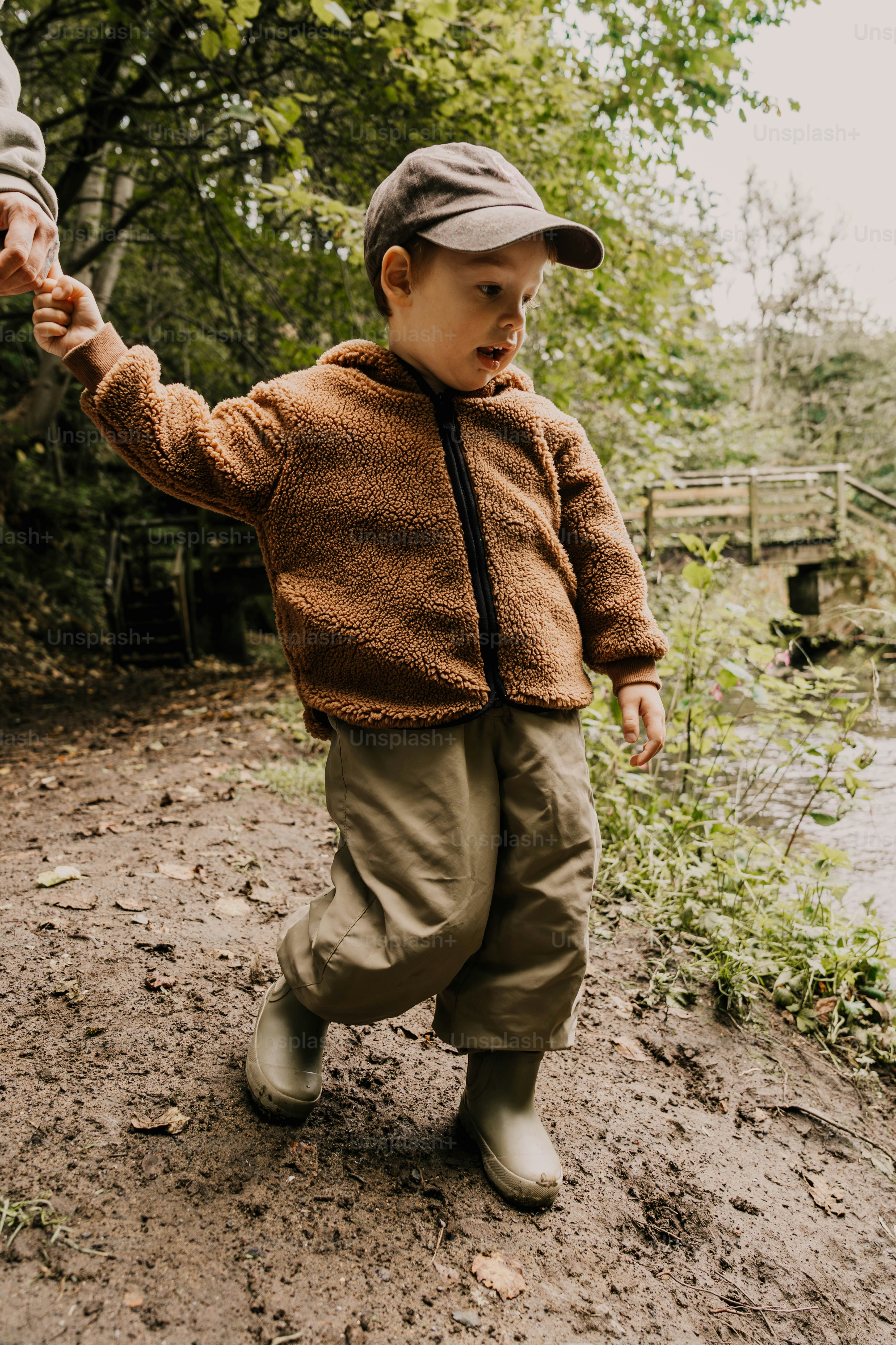 A young boy holding the hand of an older man